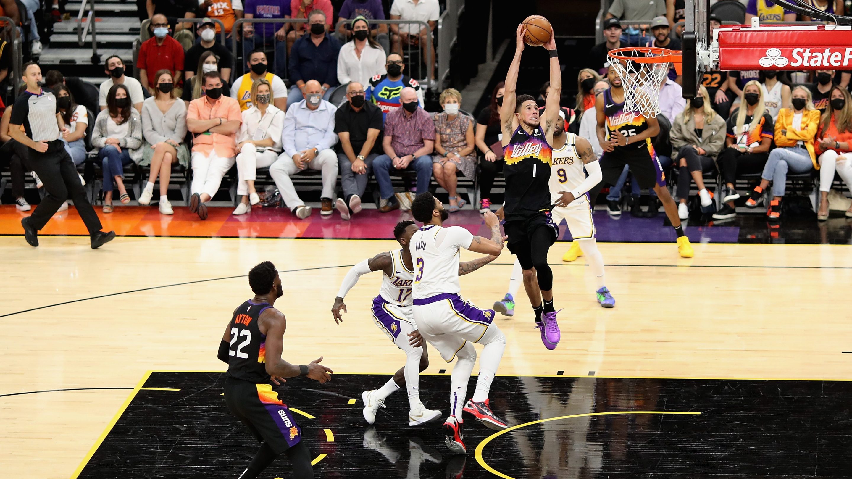 Devin Booker #1 of the Phoenix Suns slam dunks the ball past Anthony Davis #3 of the Los Angeles Lakers during the first half of Game One of the Western Conference first-round playoff series at Phoenix Suns Arena on May 23, 2021 in Phoenix, Arizona. The Suns defeated the Lakers 99-90.