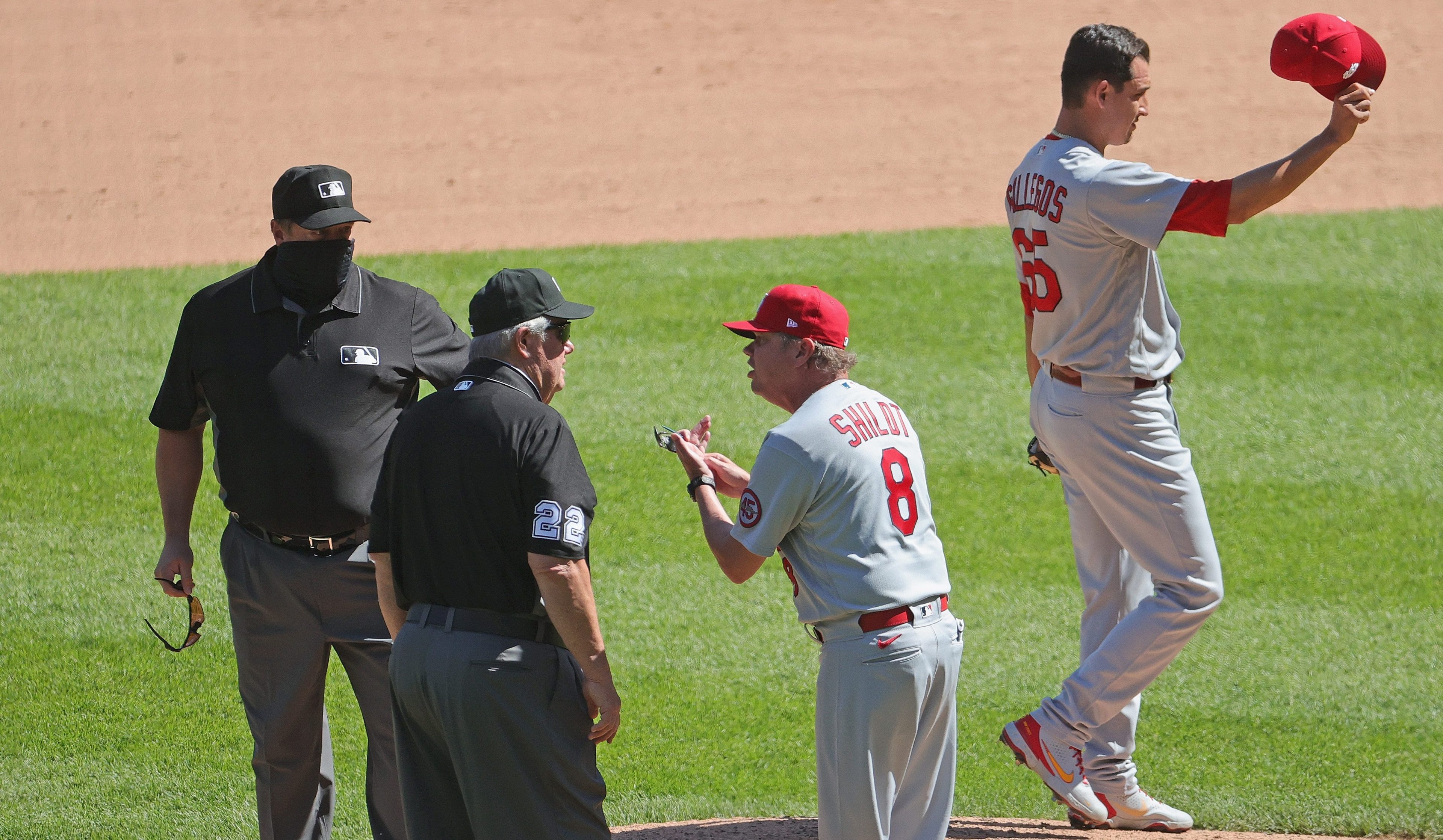 Mike Shildt argues with Joe West while Giovanny Gallegos shows off the offending hat.