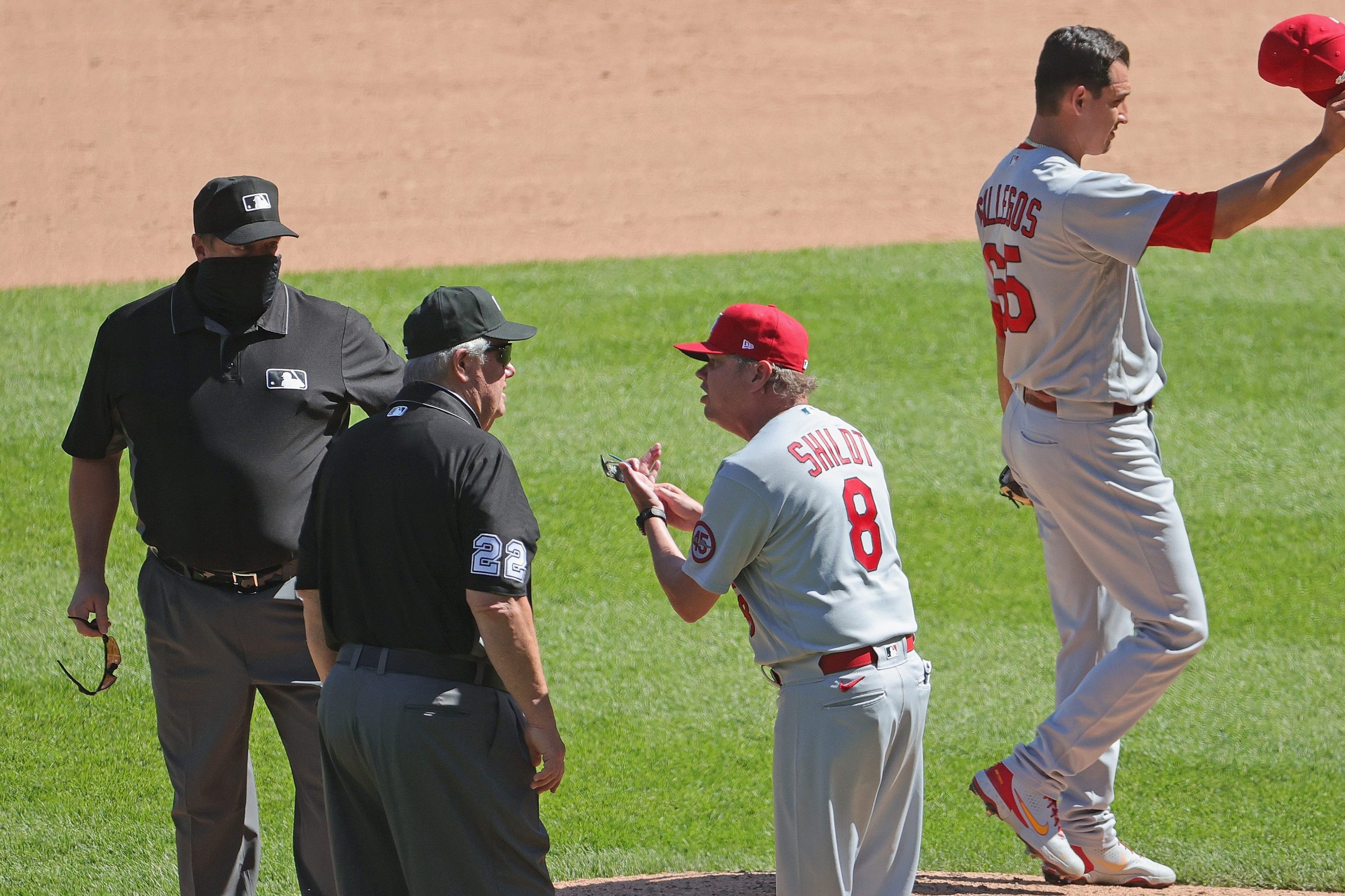 Mike Shildt argues with Joe West while Giovanny Gallegos shows off the offending hat.