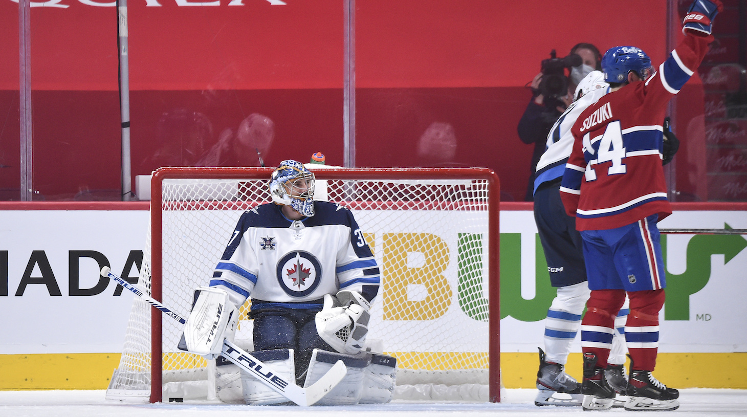 MONTREAL, QC - JUNE 06: Goaltender Connor Hellebuyck #37 of the Winnipeg Jets looks at Nick Suzuki #14 of the Montreal Canadiens as he celebrates his goal during the third period in Game Three of the Second Round of the 2021 Stanley Cup Playoffs at the Bell Centre on June 6, 2021 in Montreal, Canada. The Montreal Canadiens defeated the Winnipeg Jets 5-1. (Photo by Minas Panagiotakis/Getty Images)
