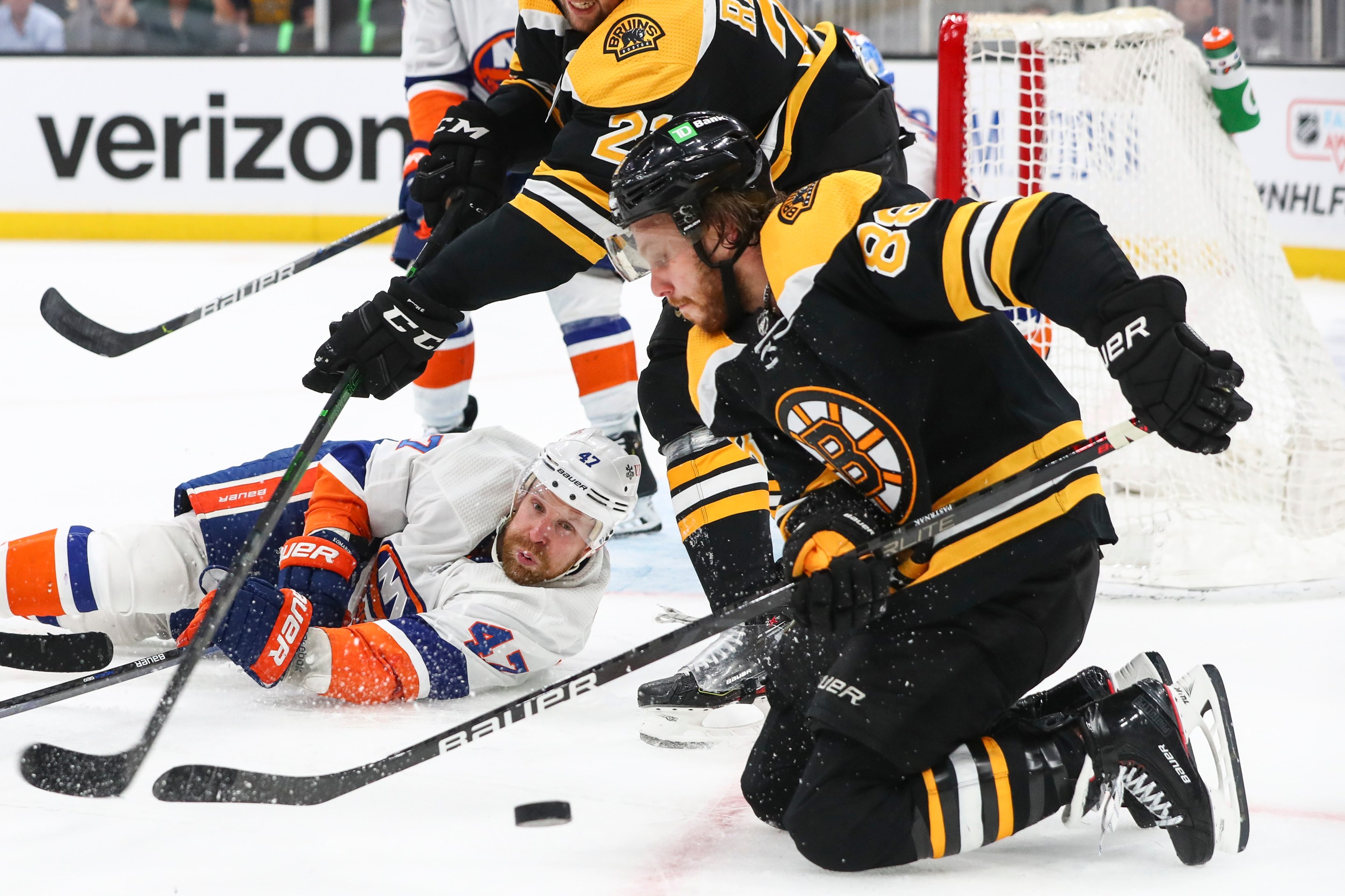 Leo Komarov and David Pastrnak fight for the puck