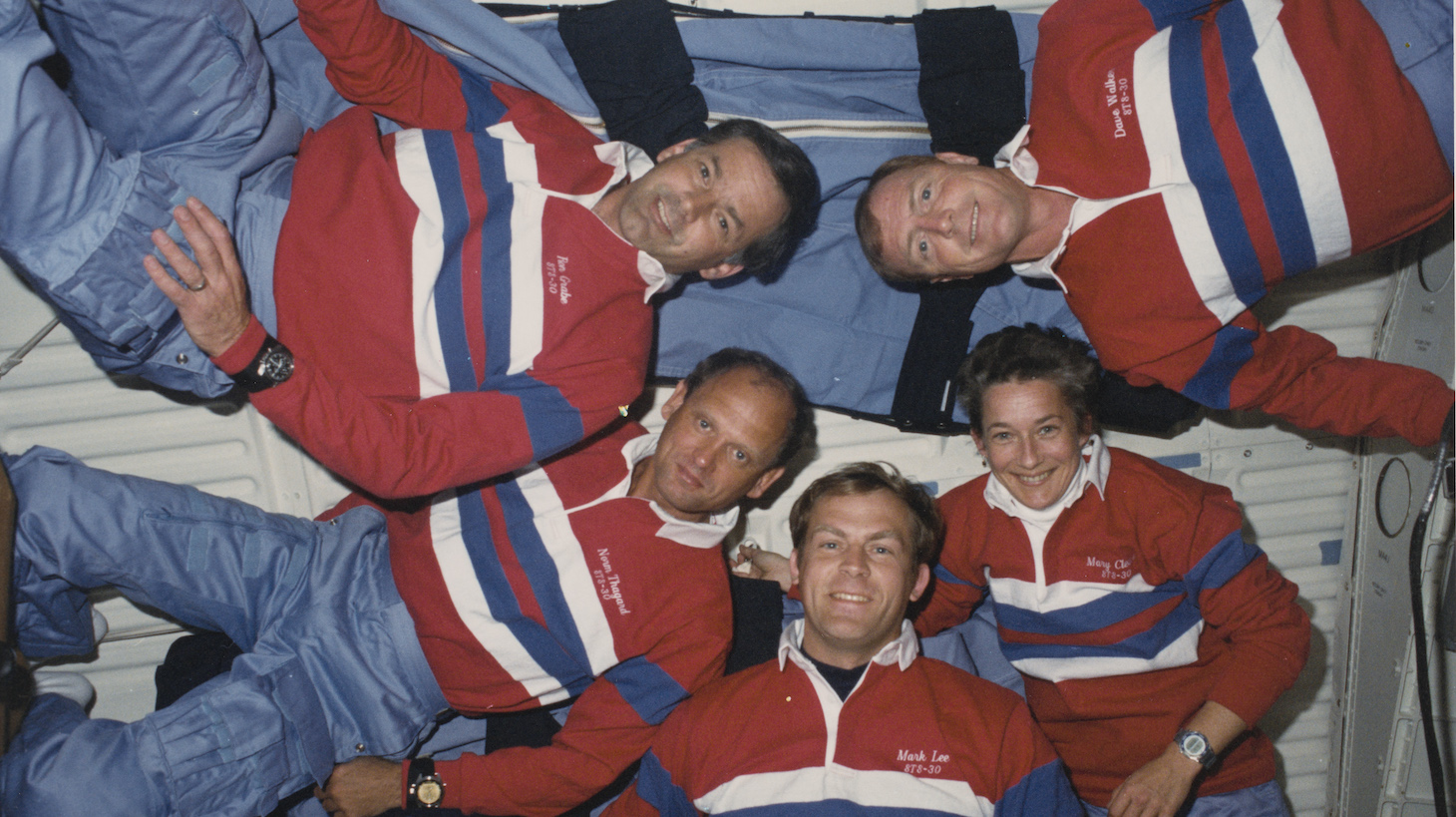 The crew of NASA's STS-30 mission pose in front of the mid-deck starboard wall-mounted sleep restraints on the Space Shuttle Atlantis (Orbiter Vehicle OV 104), 8th May 1989. Clockwise from top right, they are Commander David M Walker, mission specialists Mary L Cleave, Mark C Lee and Norman E Thagard, and pilot Ronald J Grabe. They are wearing red, white and blue mission polo shirts and light blue flight overalls. (Photo by Space Frontiers/Getty Images)