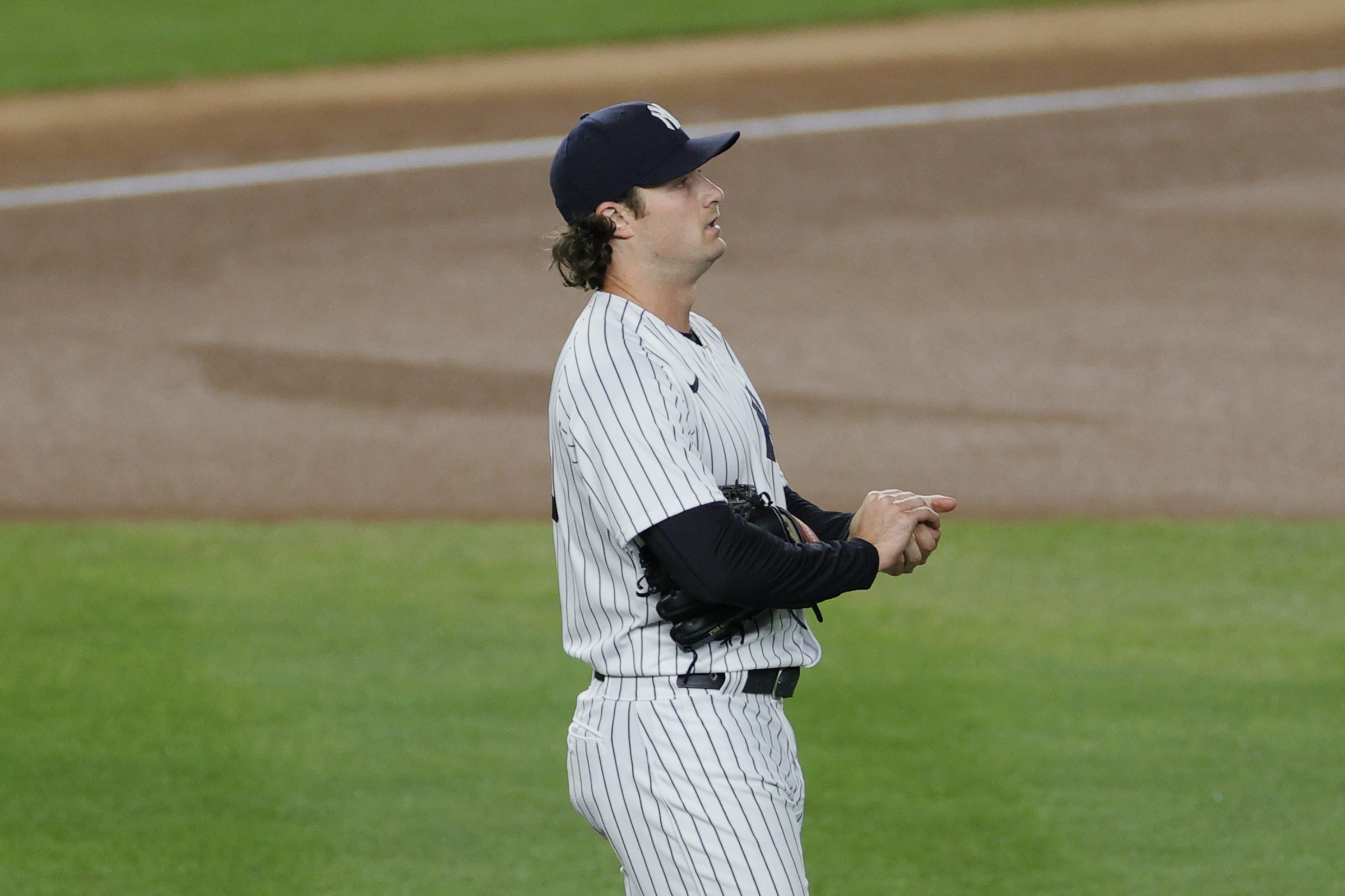 Gerrit Cole of the Yankees rubs up a baseball, with what we can presume is nothing at all, just a normal thing you do with your hands.