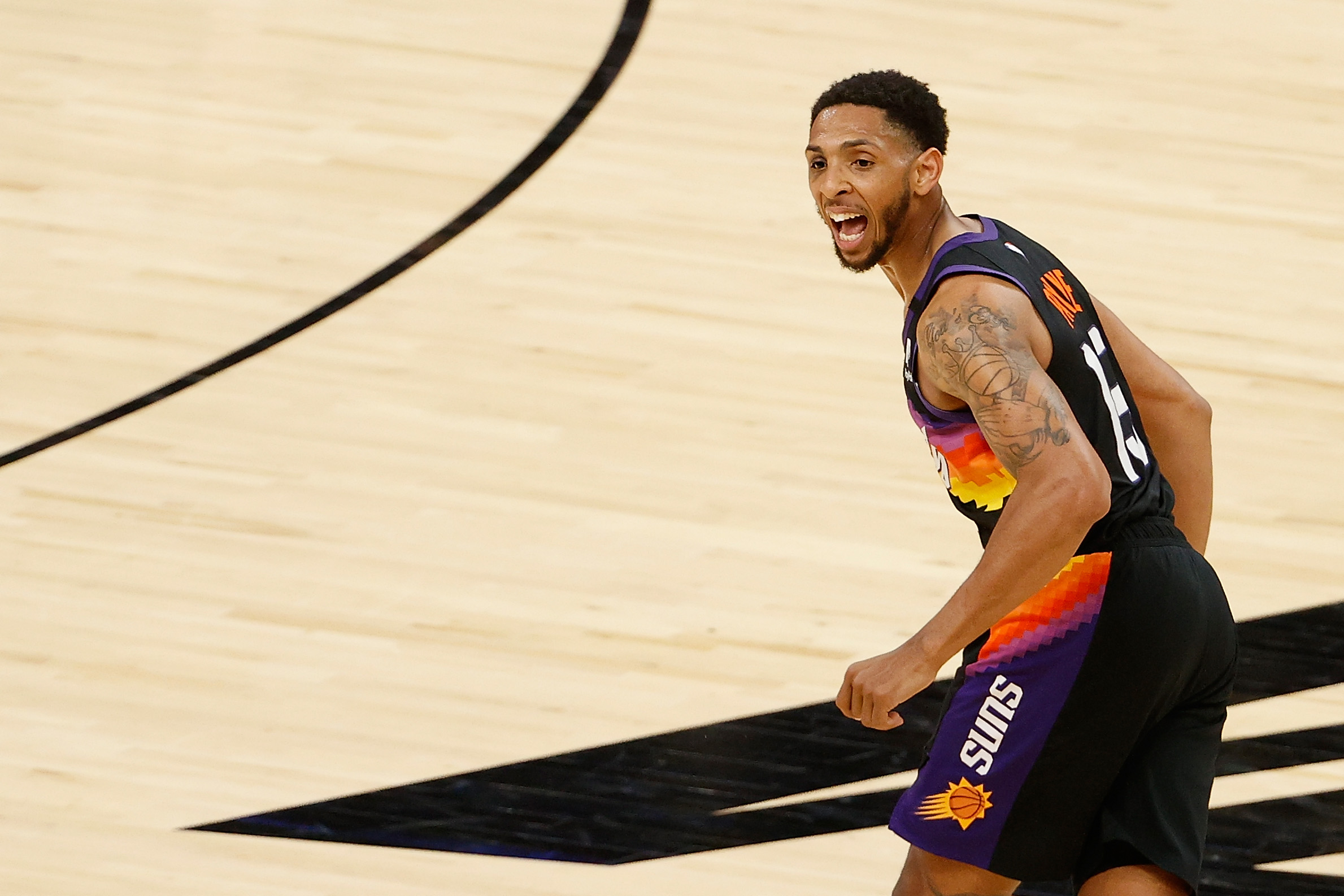 Cameron Payne in a Suns jersey, looking happy.