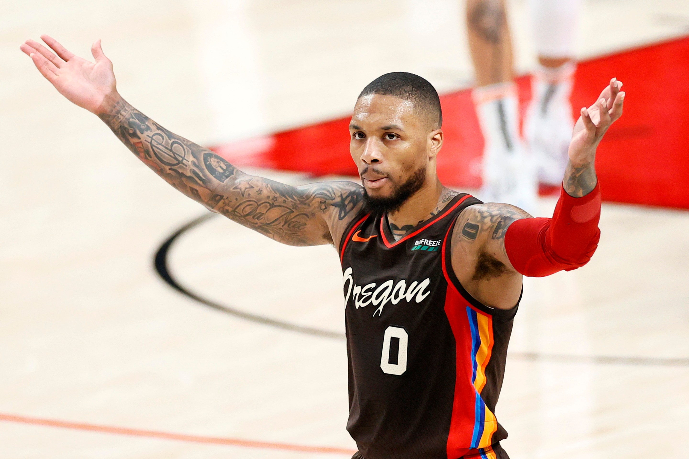 Damian Lillard gestures to the crowd during a playoff game.