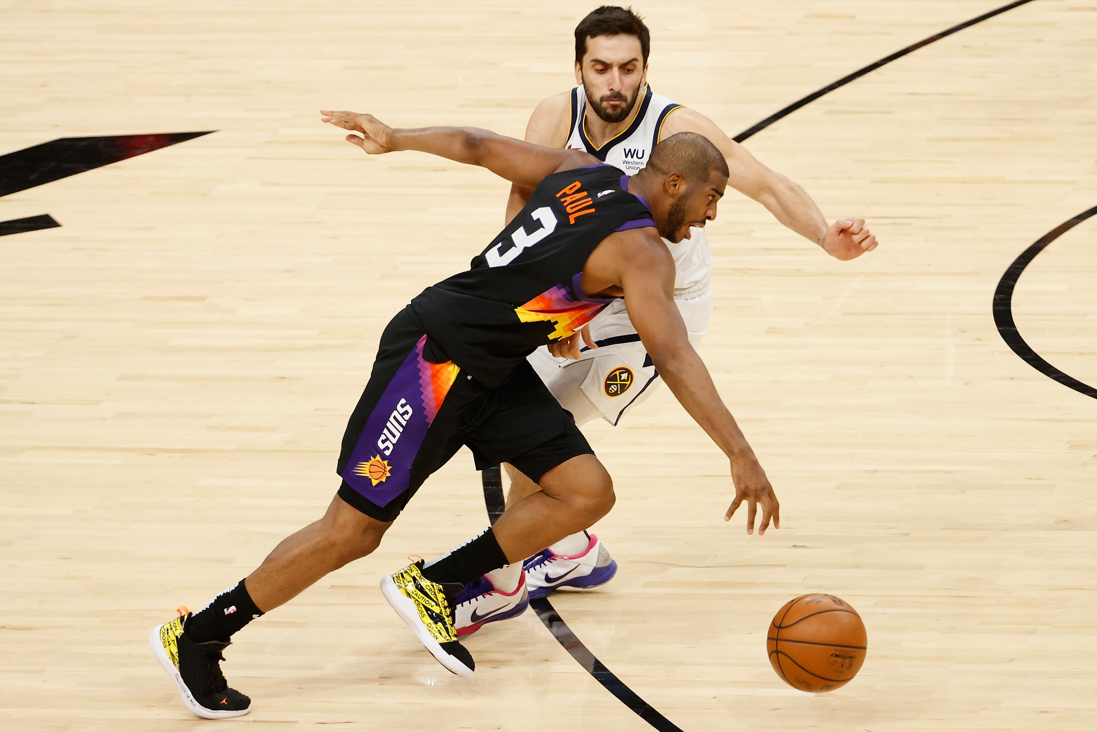 Chris Paul runs past Facundo Campazzo in a playoff game.