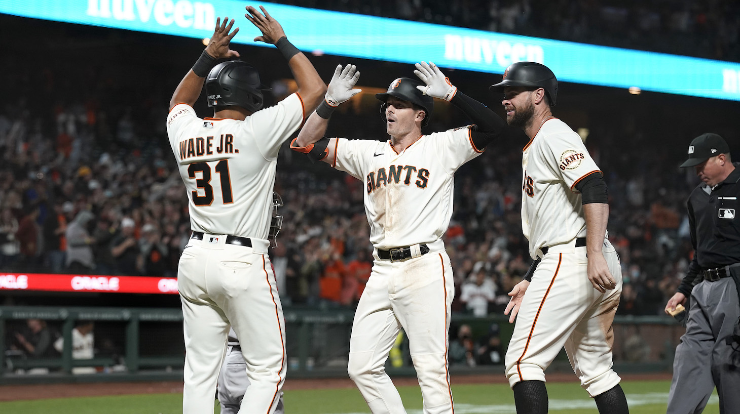 SAN FRANCISCO, CALIFORNIA - JUNE 15: Mike Yastrzemski #5, LaMonte Wade Jr #31 and Brandon Belt #9 of the San Francisco Giants celebrates after Yastrzemski hit a grand slam home run to put the Giants ahead of the Arizona Diamondbacks 9-8 in the bottom of the eighth inning at Oracle Park on June 15, 2021 in San Francisco, California. The Giants won the game 9-8. (Photo by Thearon W. Henderson/Getty Images)