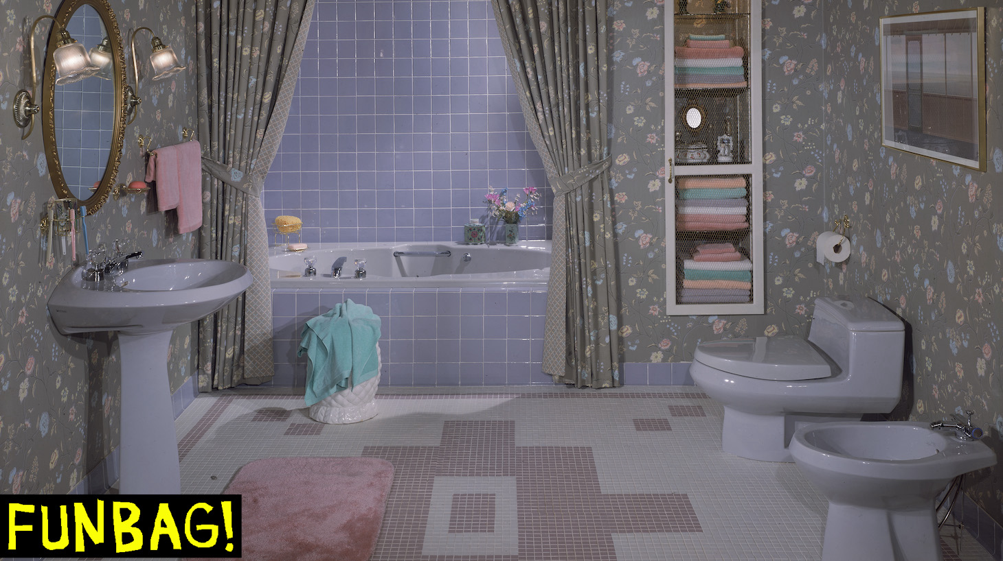 An interior view of a bathroom with matching flowered wallpaper and shower curtain and blue sink, bathtub, toilet, and tiles, circa 1985. (Photo by Frederic Lewis/Getty Images)