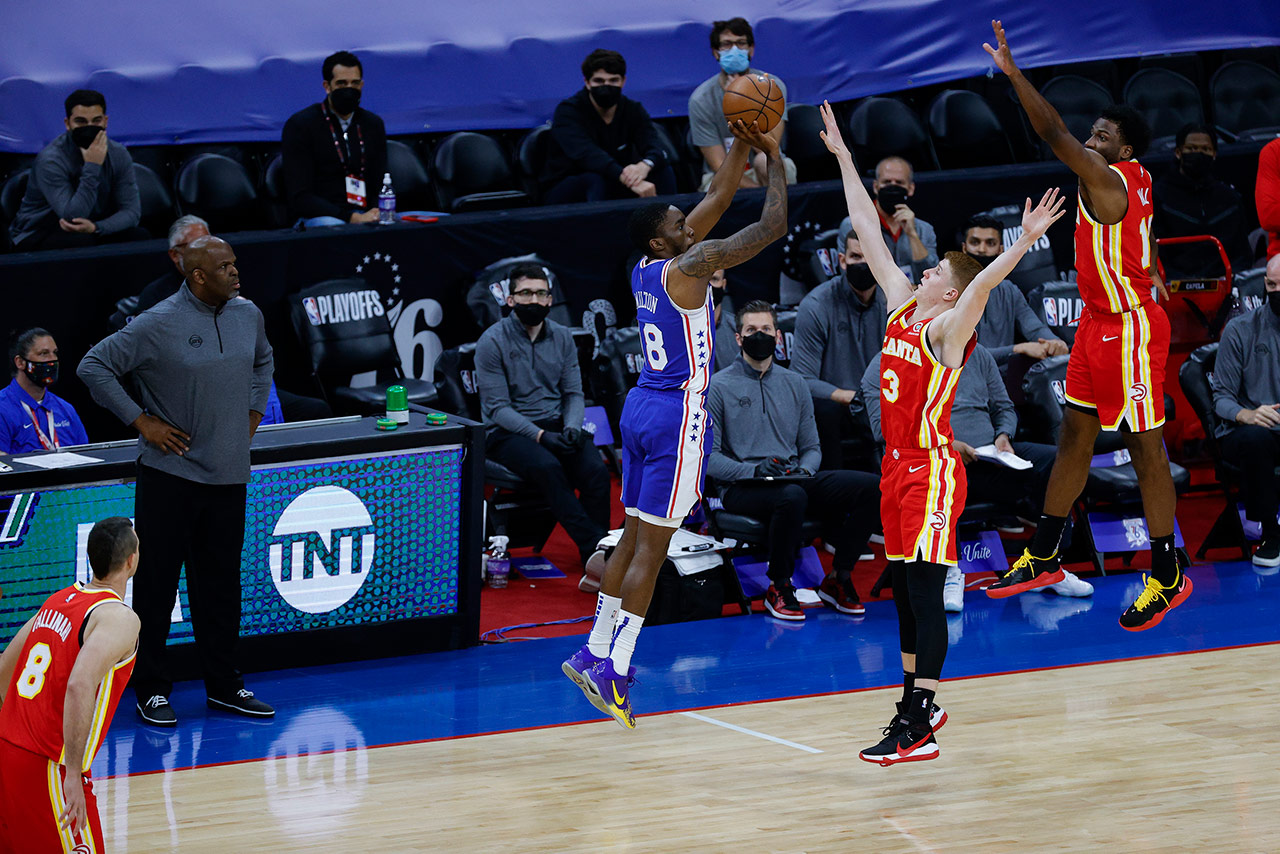 Shake Milton shooting a three pointer over three Atlanta Hawks players