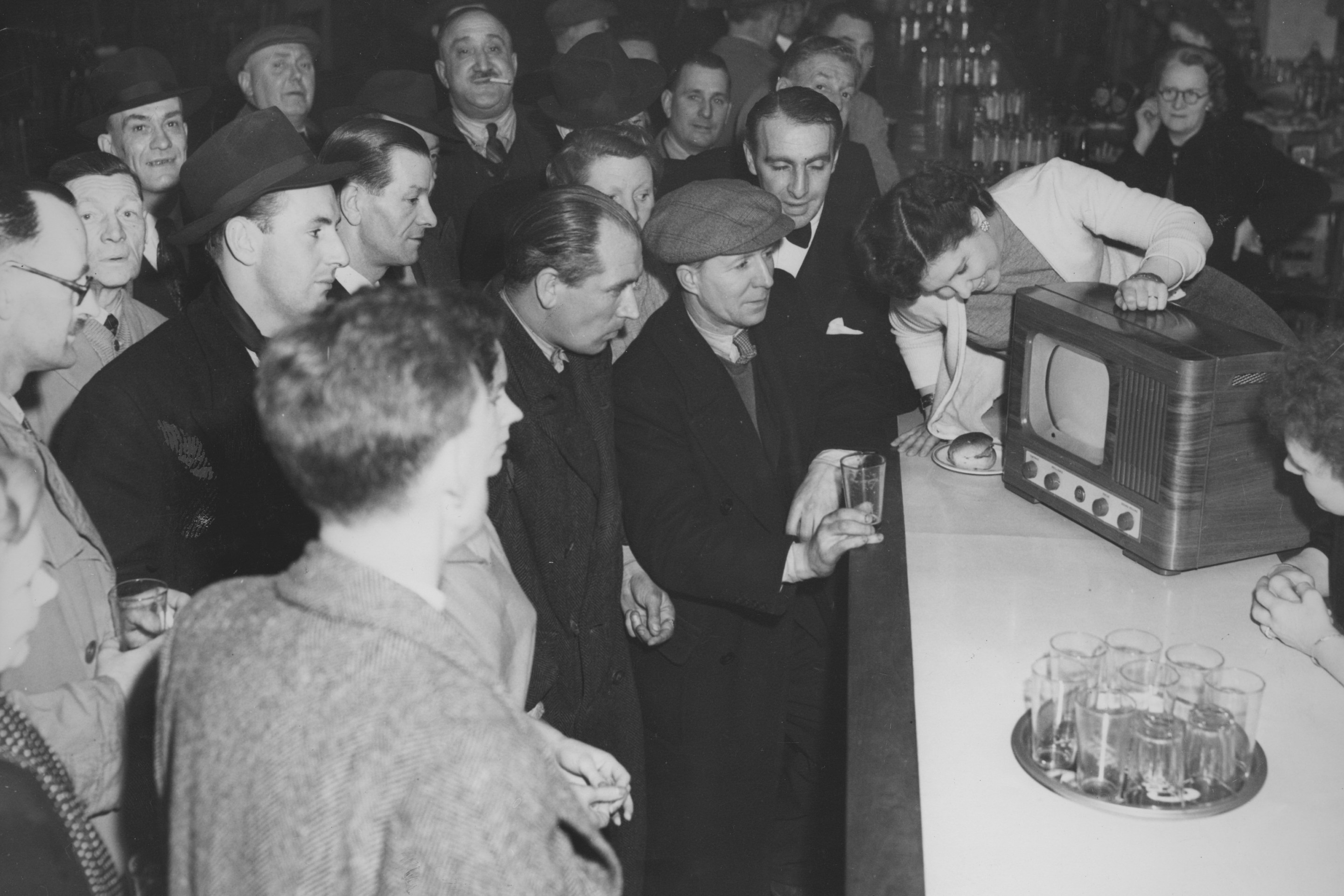 Boxing fans watch a televised fight between Albert Finch of Britain and Baby Day (Lewis Warren) of the USA, in a bar, UK, 7th February 1950. Day won on points.