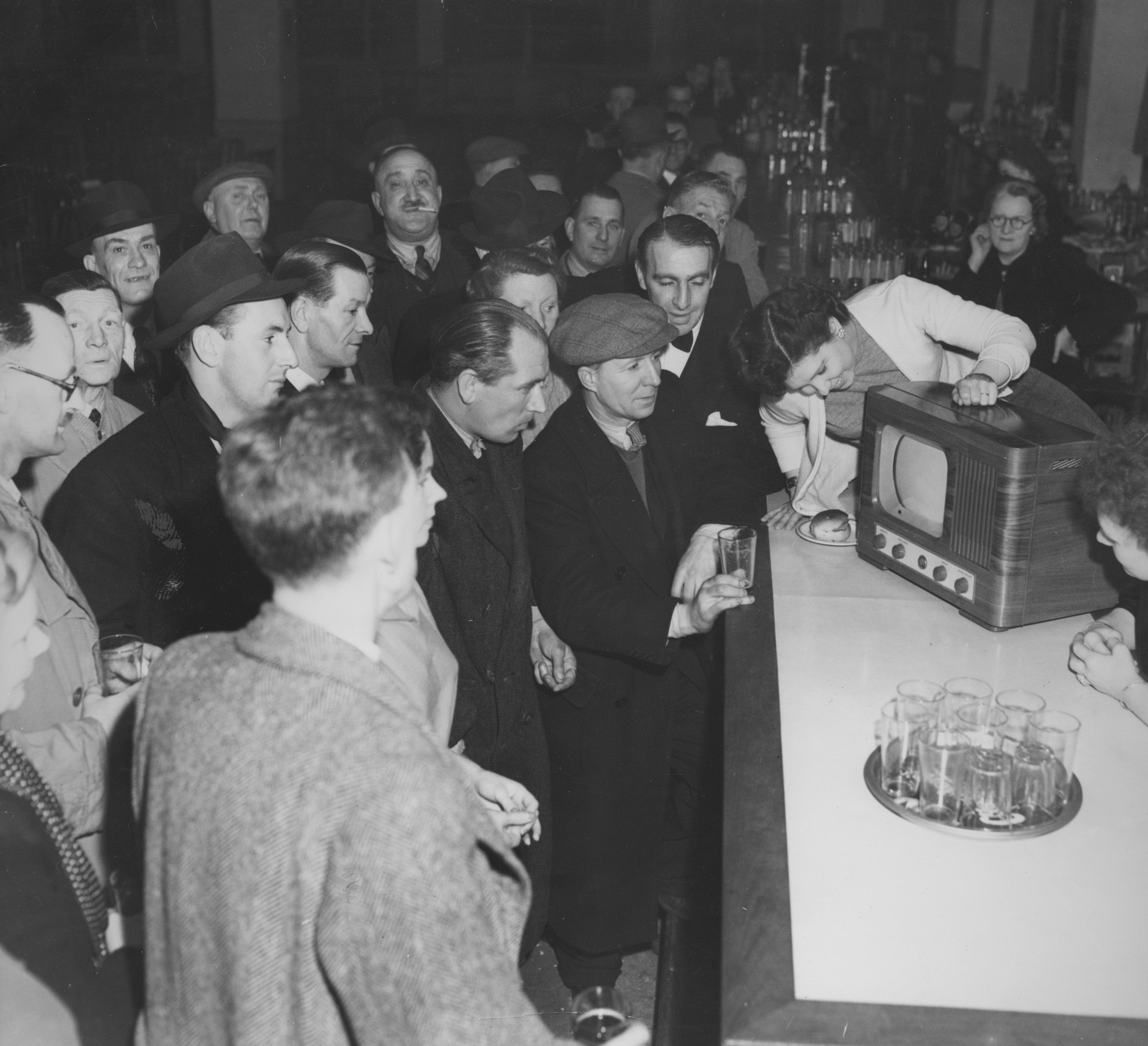 Boxing fans watch a televised fight between Albert Finch of Britain and Baby Day (Lewis Warren) of the USA, in a bar, UK, 7th February 1950. Day won on points.
