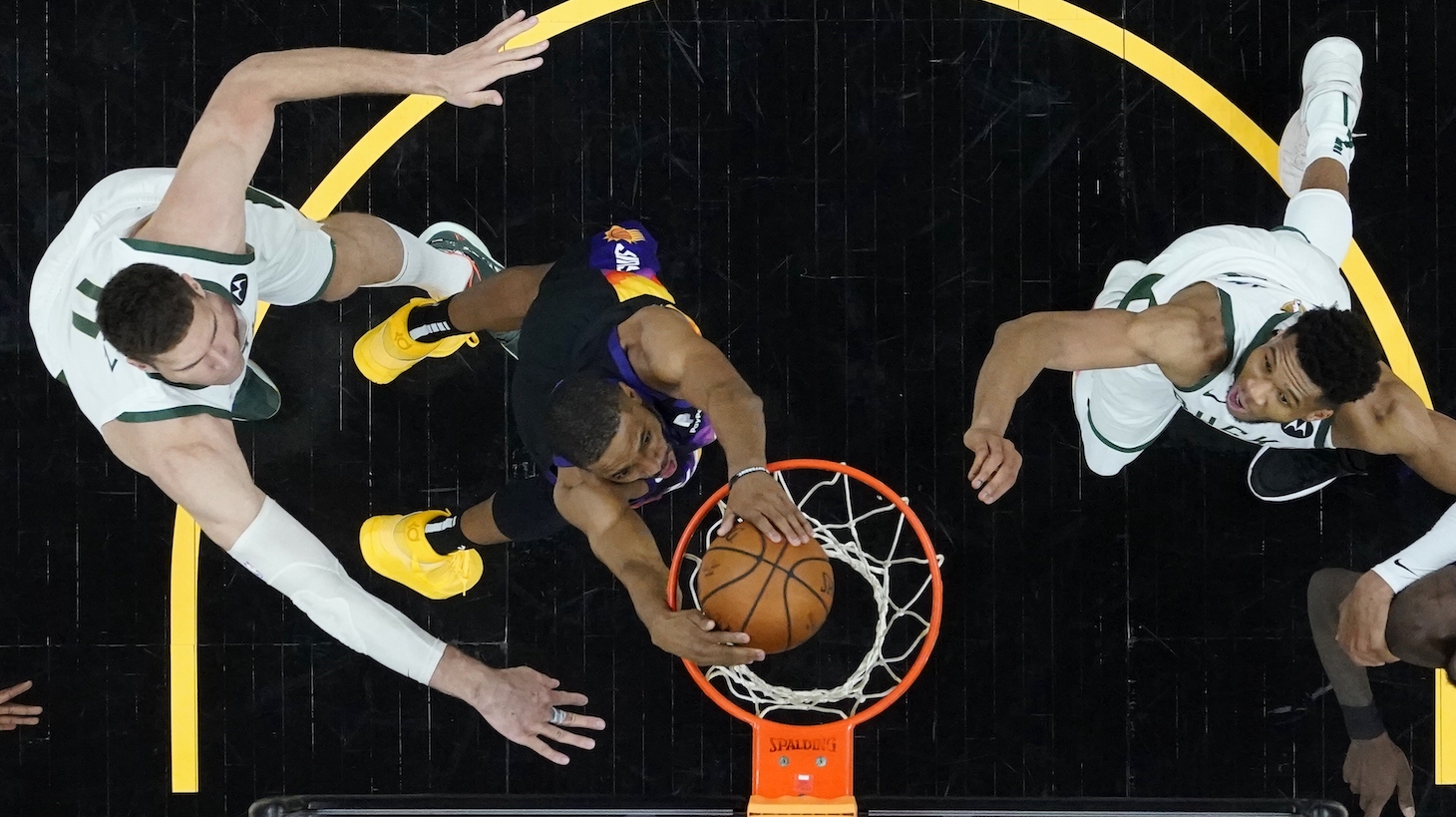PHOENIX, ARIZONA - JULY 08: Phoenix Suns forward Mikal Bridges, middle, dunks against Milwaukee Bucks center Brook Lopez, left, and Bucks forward Giannis Antetokounmpo, right, during the second half of Game Two of the NBA Finals at Phoenix Suns Arena on July 08, 2021 in Phoenix, Arizona. NOTE TO USER: User expressly acknowledges and agrees that, by downloading and or using this photograph, User is consenting to the terms and conditions of the Getty Images License Agreement. (Photo by Ross D. Franklin-Pool/Getty Images )