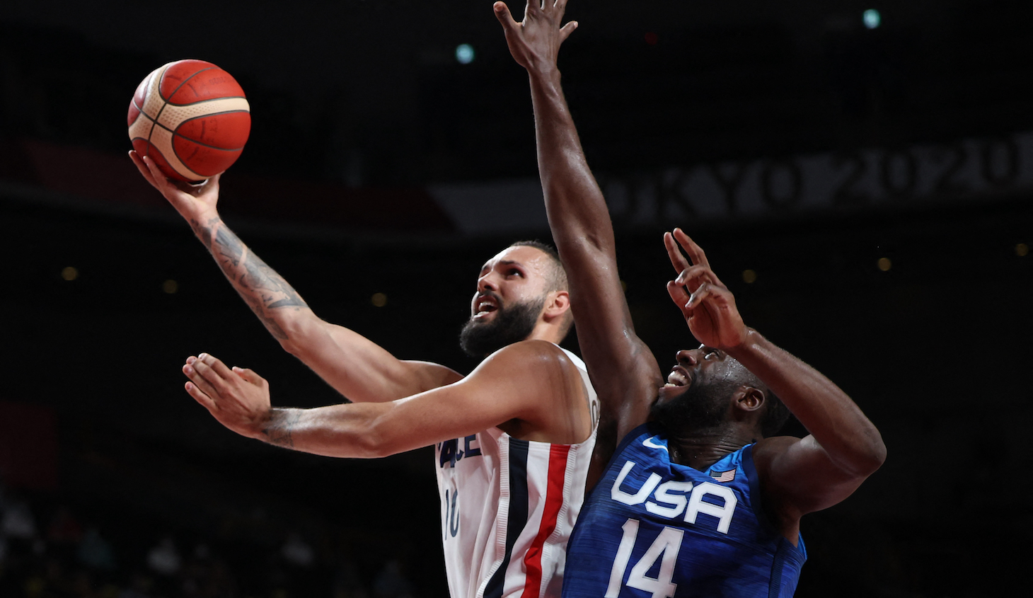 TOPSHOT - France's Evan Fournier (L) goes to the basket as USA's Draymond Jamal Green tries to block in the men's preliminary round group A basketball match between France and USA during the Tokyo 2020 Olympic Games at the Saitama Super Arena in Saitama on July 25, 2021. (Photo by Thomas COEX / AFP) (Photo by THOMAS COEX/AFP via Getty Images)