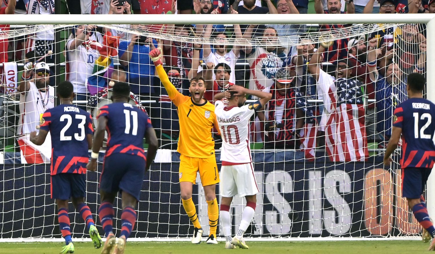 USA's goalkeeper Matt Turner (C) celebrates after Qatar's forward Hasan Al Haydos (2nd R) missed a penalty kick during the Concacaf Gold Cup semifinal football match between Qatar and USA at Q2 stadium in Austin, Texas on July 29, 2021. (Photo by Sergio FLORES / AFP) (Photo by SERGIO FLORES/AFP via Getty Images)