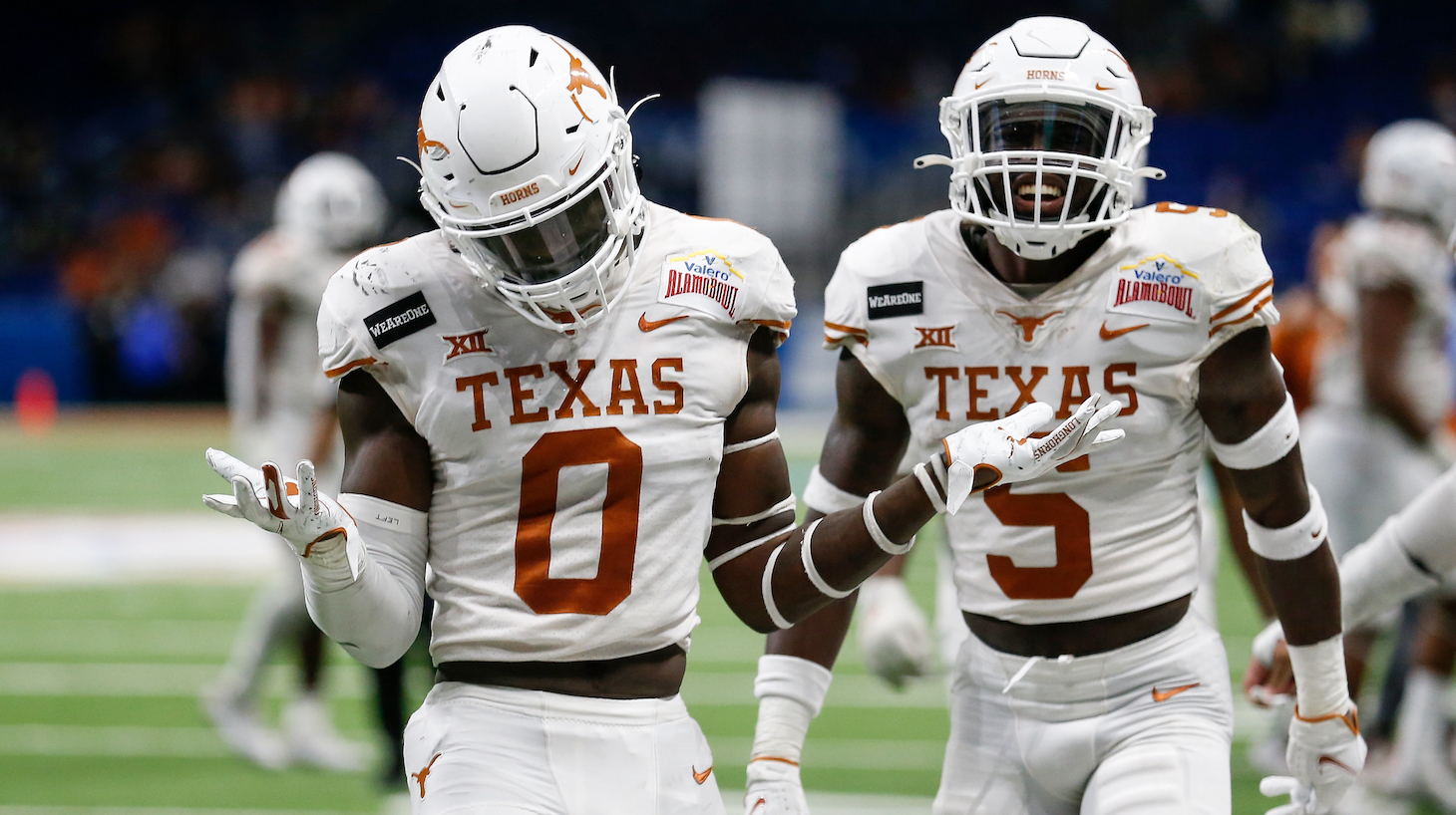 SAN ANTONIO, TEXAS - DECEMBER 29: DeMarvion Overshown #0 and D'Shawn Jamison #5 of the Texas Longhorns react after a turnover in the fourth quarter against the Colorado Buffaloes during the Valero Alamo Bowl at the Alamodome on December 29, 2020 in San Antonio, Texas. (Photo by Tim Warner/Getty Images)