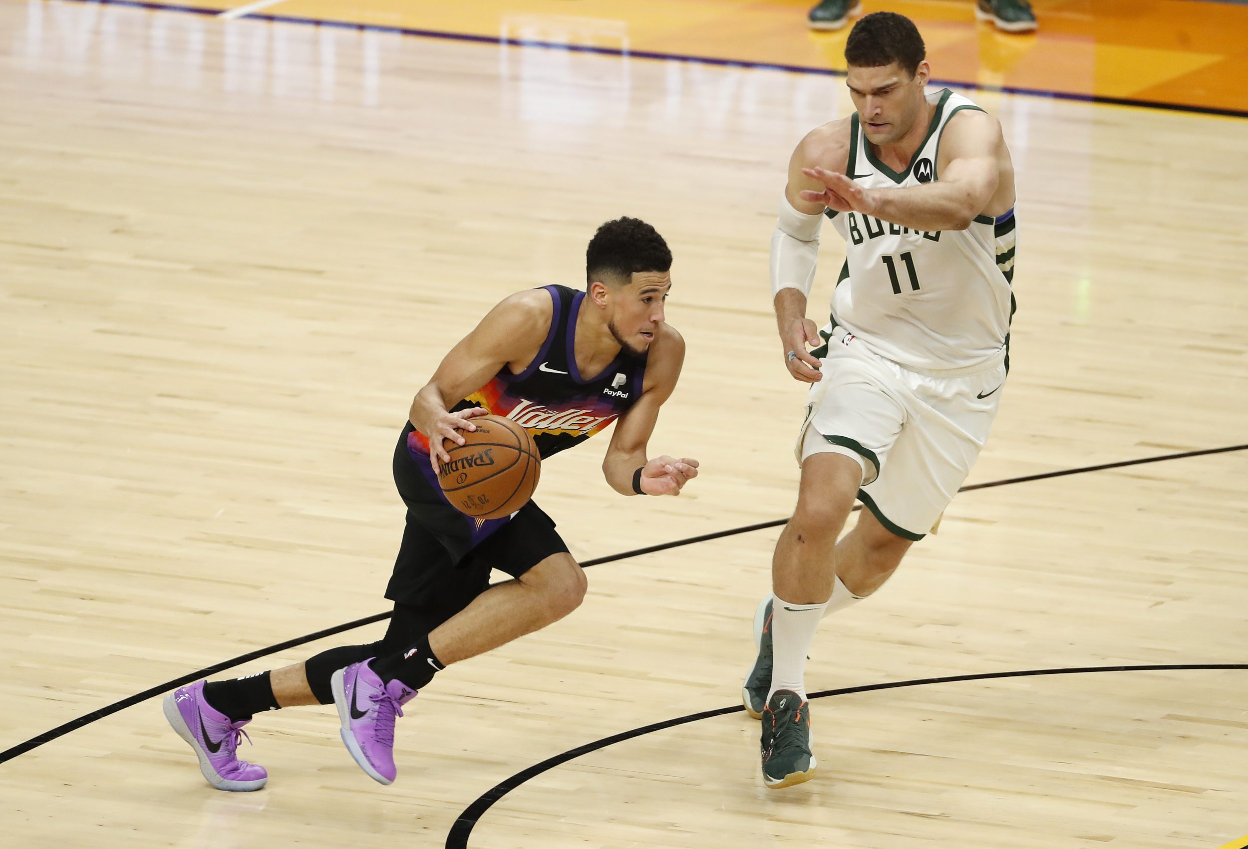 Brook Lopez tries and fails to guard Devin Booker.
