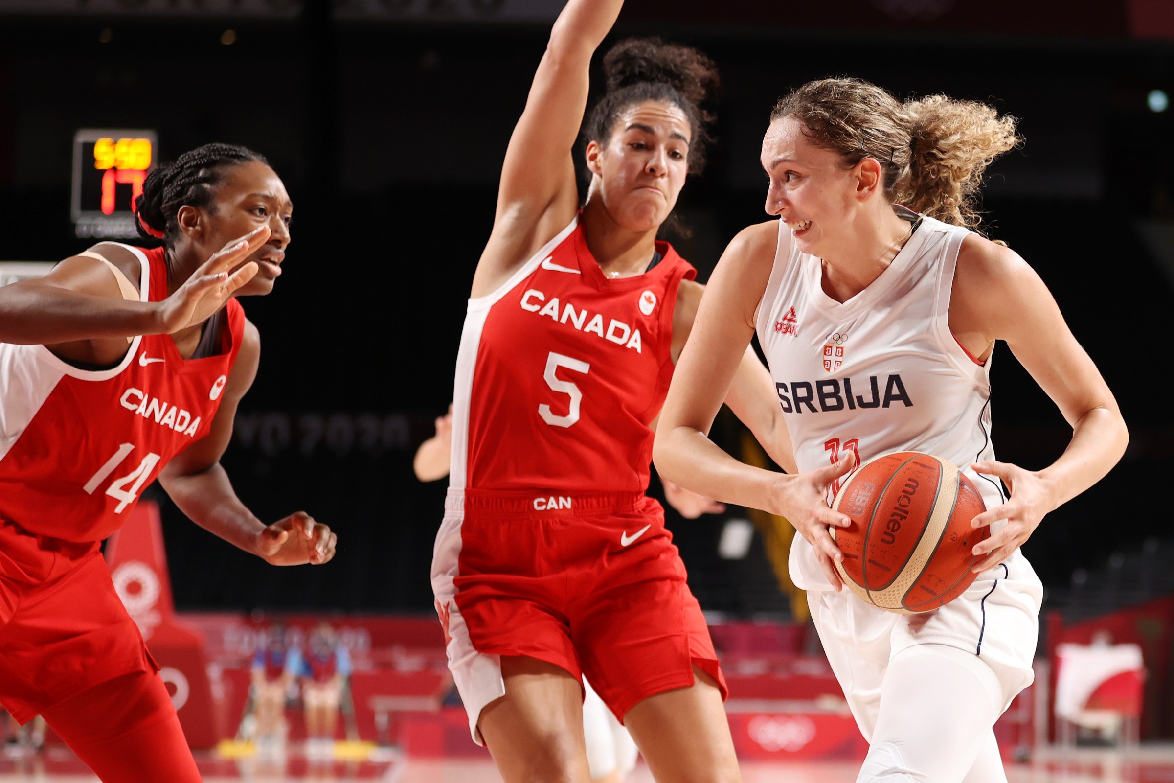 Aleksandra Crvendakic #11 of Team Serbia drives to the basket against Kayla Alexander #14 and Kia Nurse #5 of Team Canada during the first half of the Women's Preliminary Round Group A game on day three of the Tokyo 2020 Olympic Games at Saitama Super Arena on July 26, 2021 in Saitama, Japan.