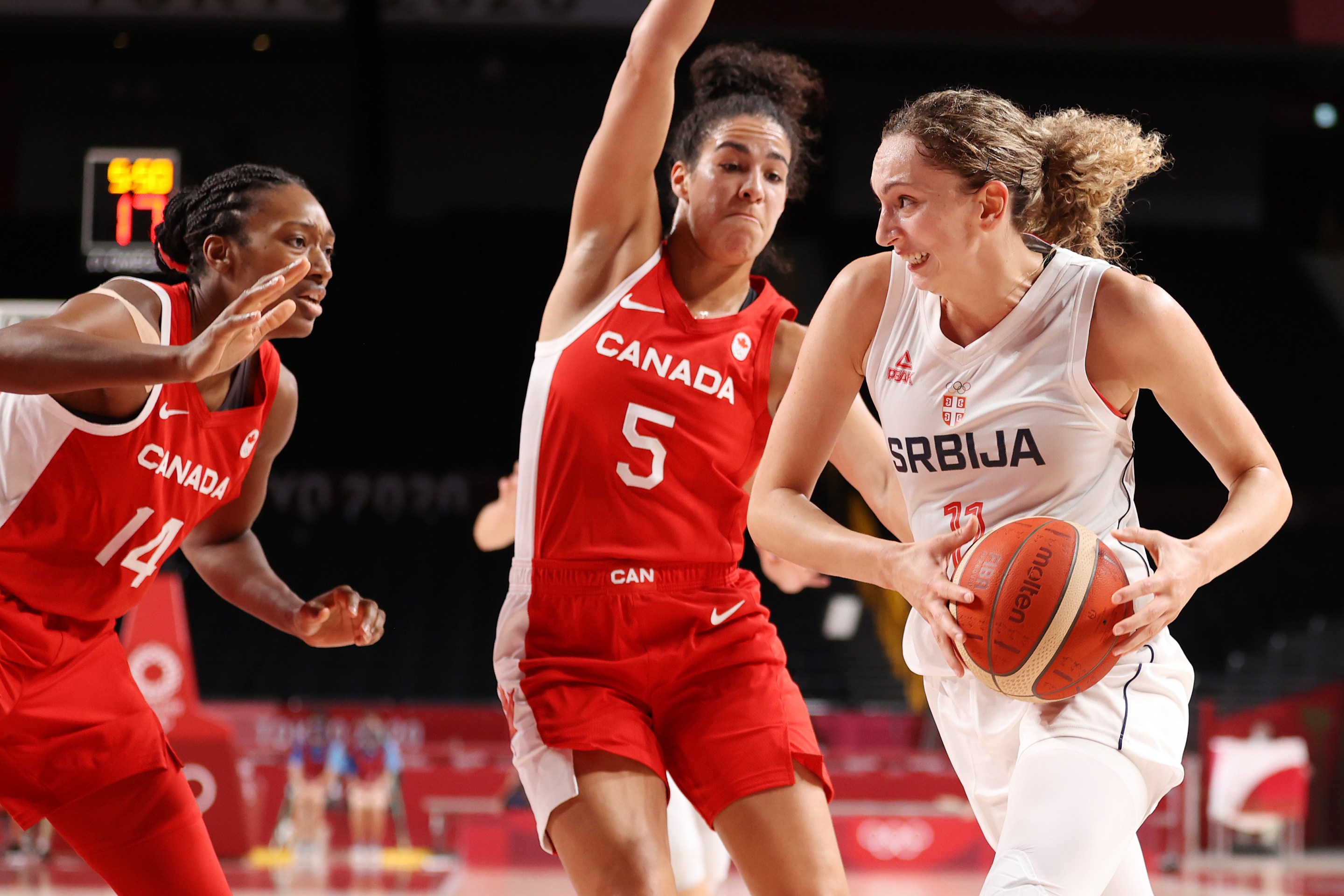 Aleksandra Crvendakic #11 of Team Serbia drives to the basket against Kayla Alexander #14 and Kia Nurse #5 of Team Canada during the first half of the Women's Preliminary Round Group A game on day three of the Tokyo 2020 Olympic Games at Saitama Super Arena on July 26, 2021 in Saitama, Japan.