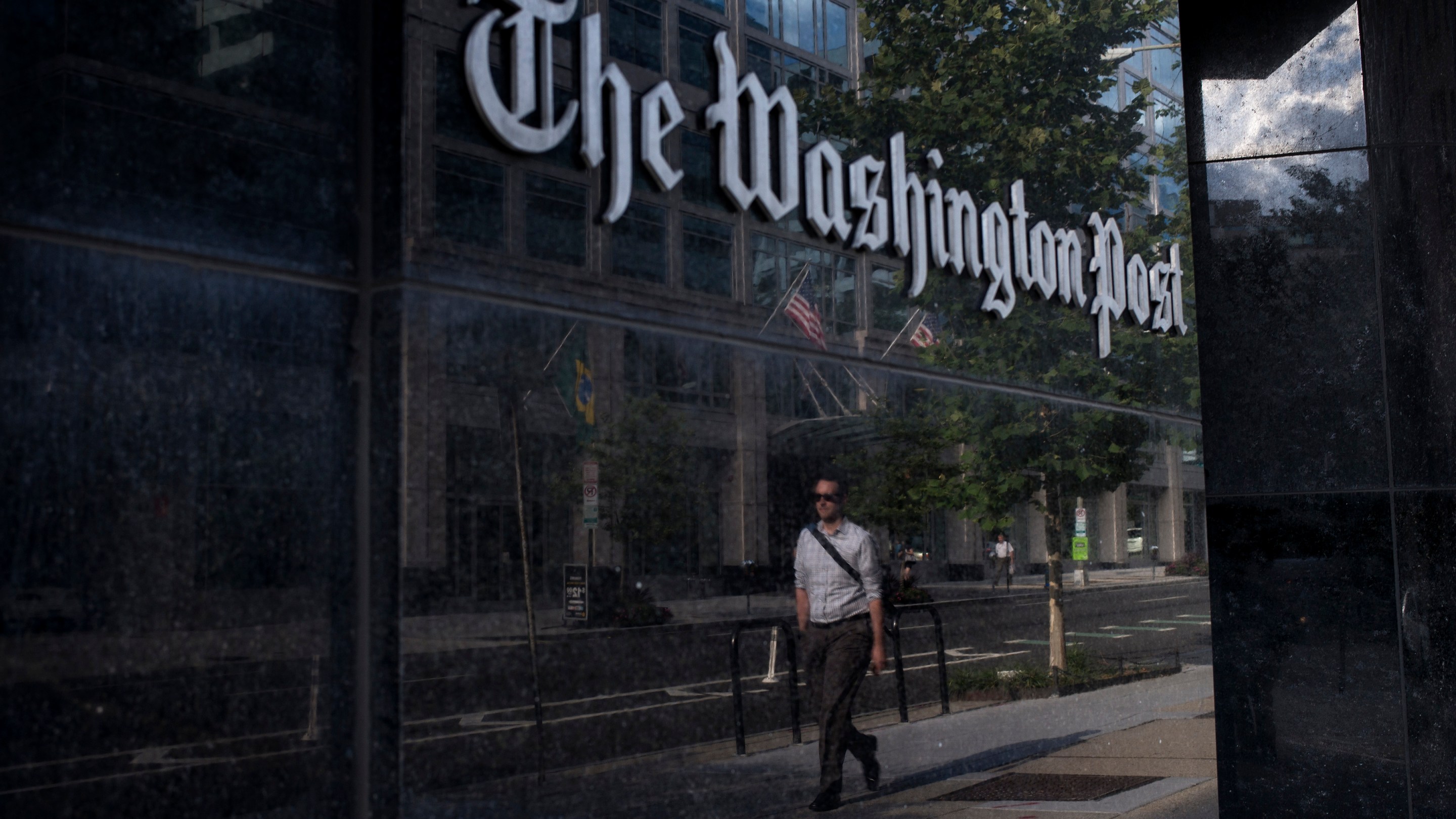 A man walks past The Washington Post on August 5, 2013 in Washington, DC after it was announced that Amazon.com founder and CEO Jeff Bezos had agreed to purchase the Post for USD 250 million. Multi-billionaire Bezos, who created Amazon, which has soared in a few years to a dominant position in online retailing, said he was buying the Post in his personal capacity and hoped to shepherd it through the evolution away from traditional newsprint.