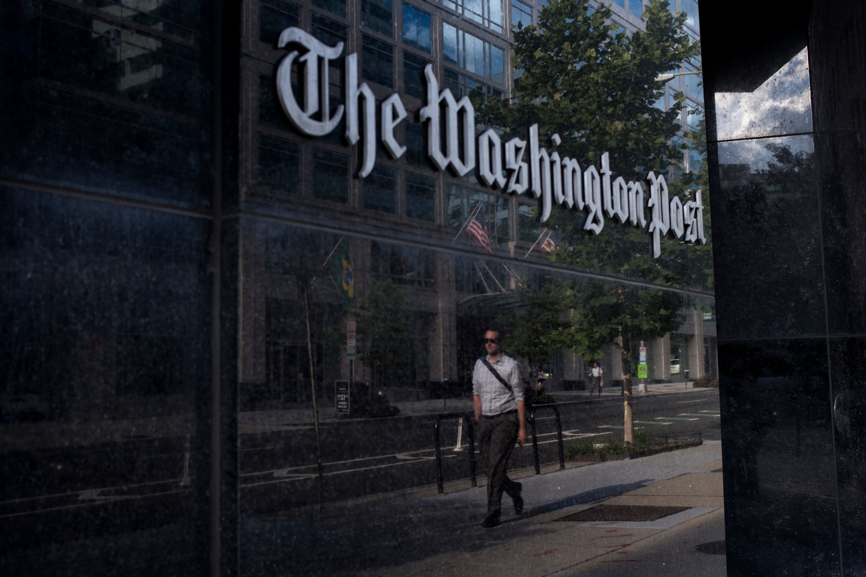 A man walks past The Washington Post on August 5, 2013 in Washington, DC after it was announced that Amazon.com founder and CEO Jeff Bezos had agreed to purchase the Post for USD 250 million. Multi-billionaire Bezos, who created Amazon, which has soared in a few years to a dominant position in online retailing, said he was buying the Post in his personal capacity and hoped to shepherd it through the evolution away from traditional newsprint.