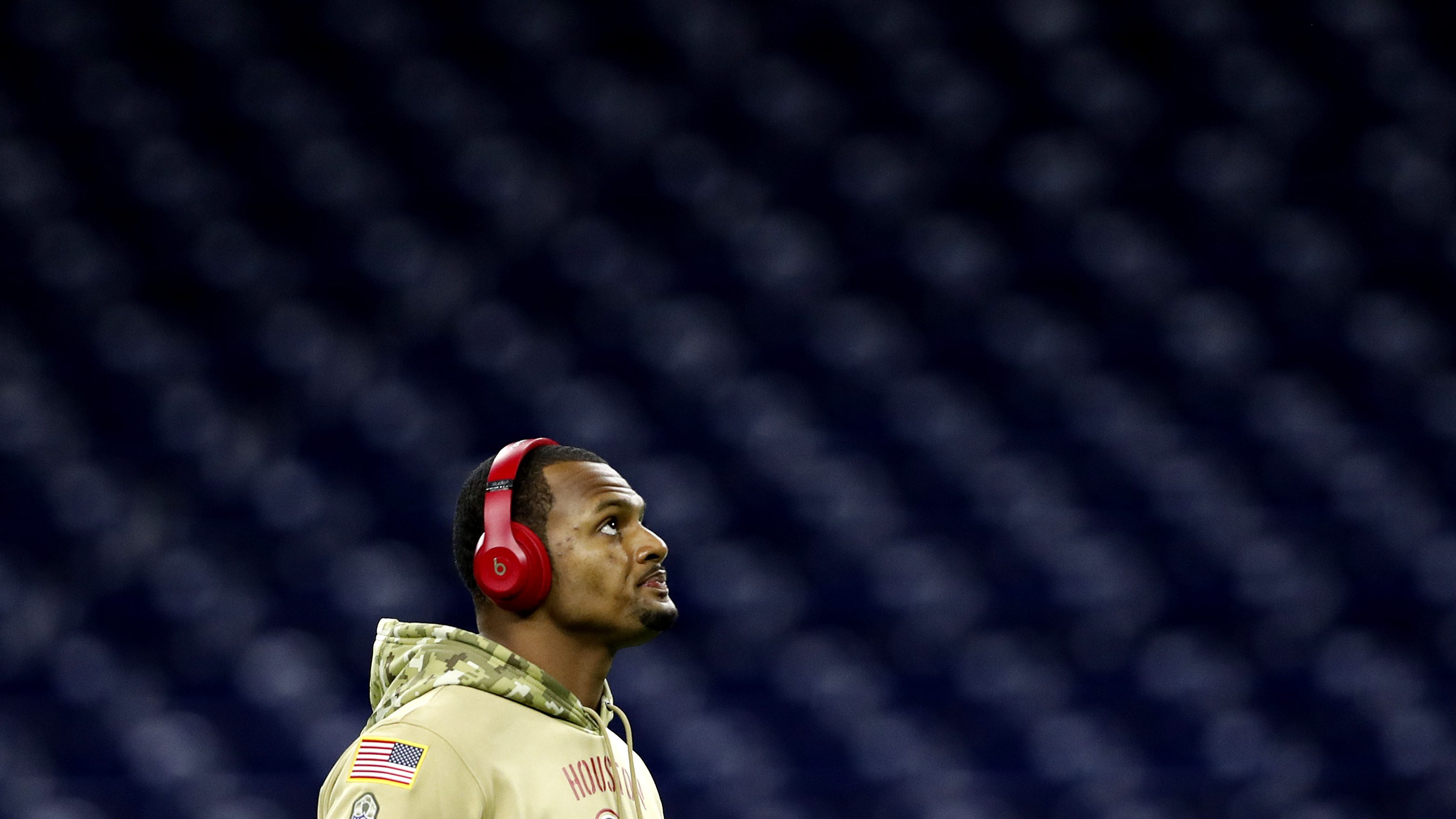 Deshaun Watson #4 of the Houston Texans warms up prior to the game against the New England Patriots at NRG Stadium on December 01, 2019 in Houston, Texas. He is in a green camo hoodie and wearing red headphone.