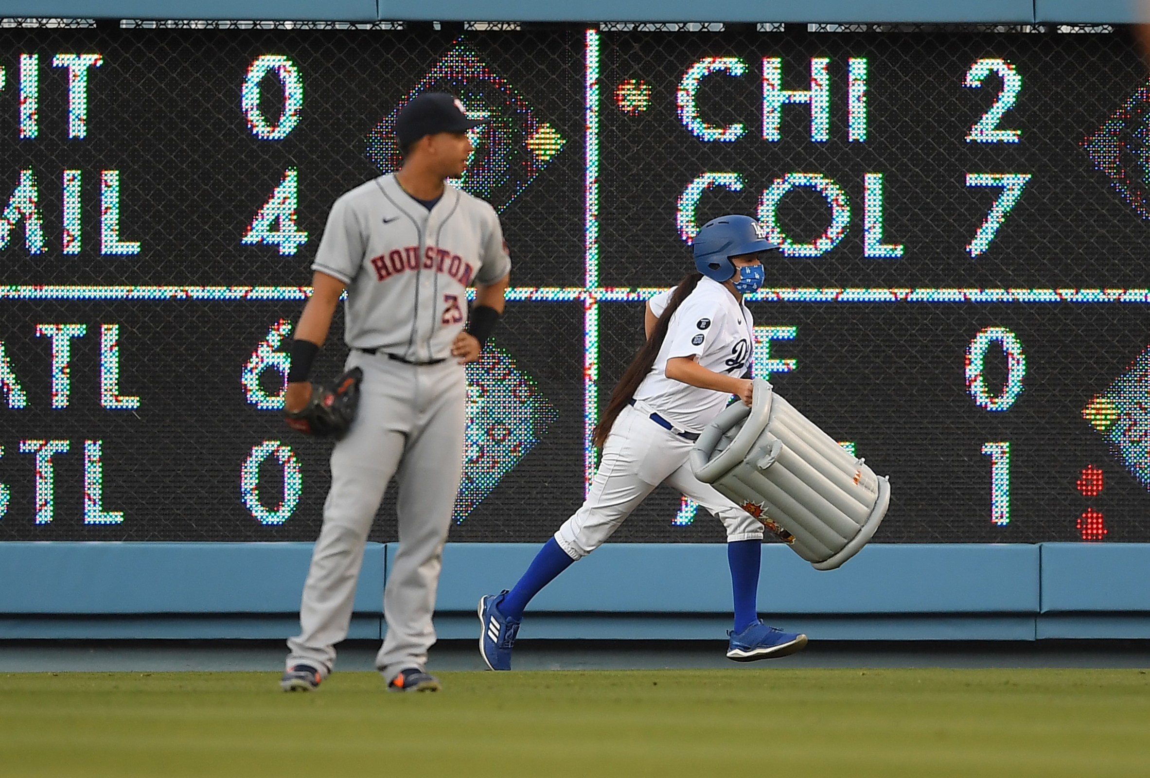 Michael Brantley watches as a bat girl removes an inflatable trash can