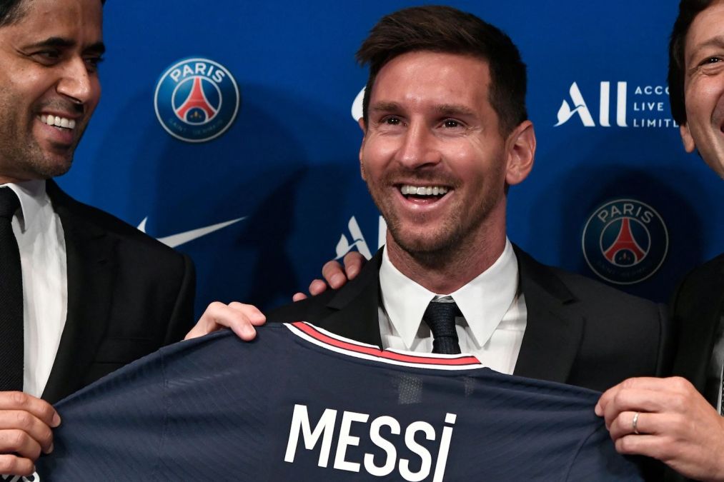 Paris Saint-Germain's Qatari President Nasser Al-Khelaifi (L) and Paris Saint-Germain's Sporting Director Leonardo Nascimento de Araujo (R) pose along side Argentinian football player Lionel Messi (C) as he holds-up his number 30 shirt during a press conference at the French football club Paris Saint-Germain's (PSG) Parc des Princes stadium in Paris on August 11, 2021. - The 34-year-old superstar signed a two-year deal with PSG on August 10, 2021, with the option of an additional year, he will wear the number 30 in Paris, the number he had when he began his professional career at Spain's Barca football club.