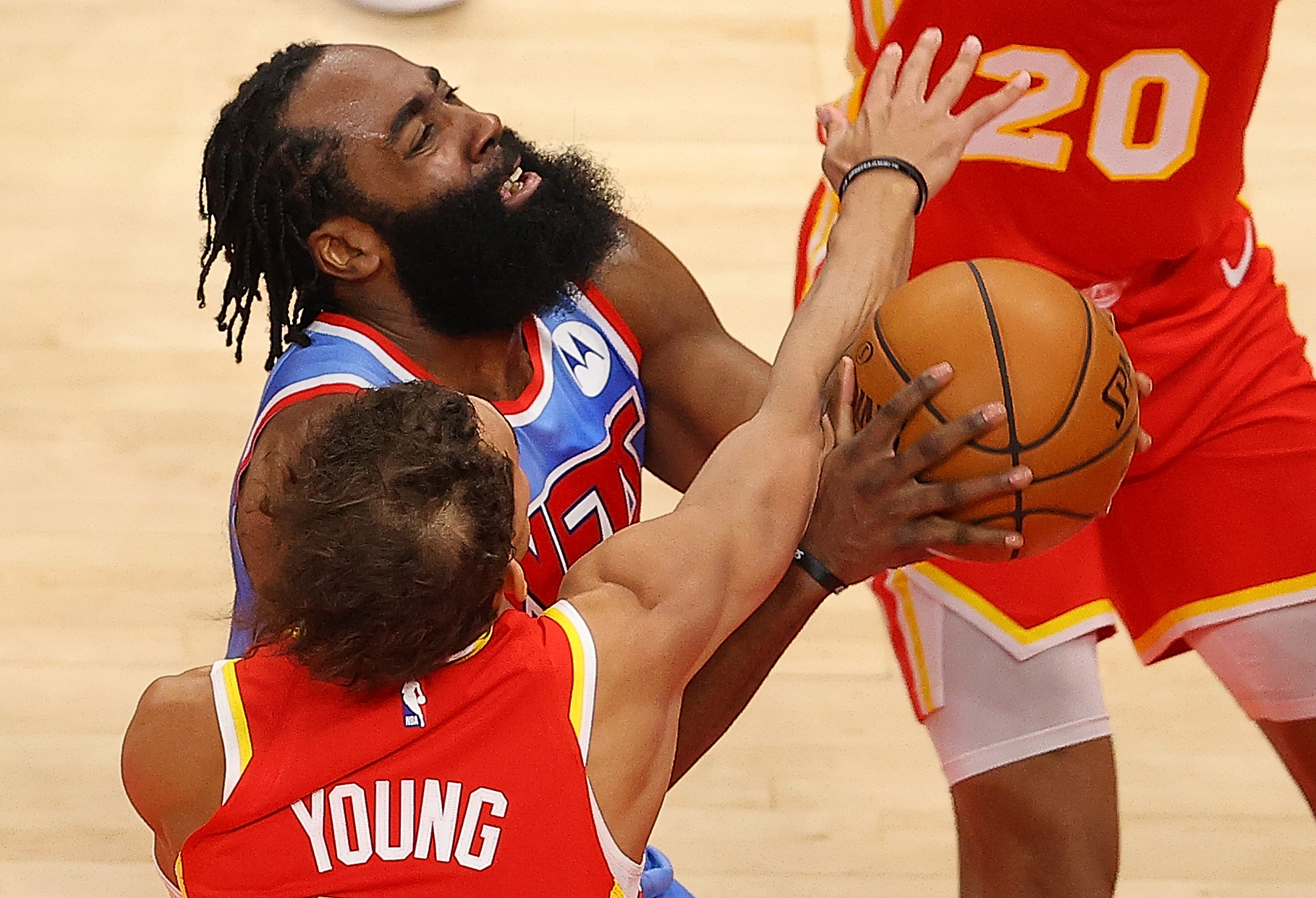 James Harden of the Brooklyn Nets is fouled by Trae Young of the Atlanta Hawks.