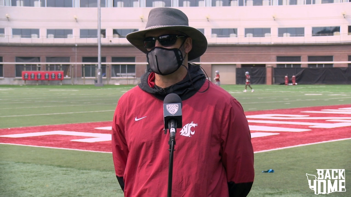 Washington State football coach Nick Rolovich addresses the media in a mask.