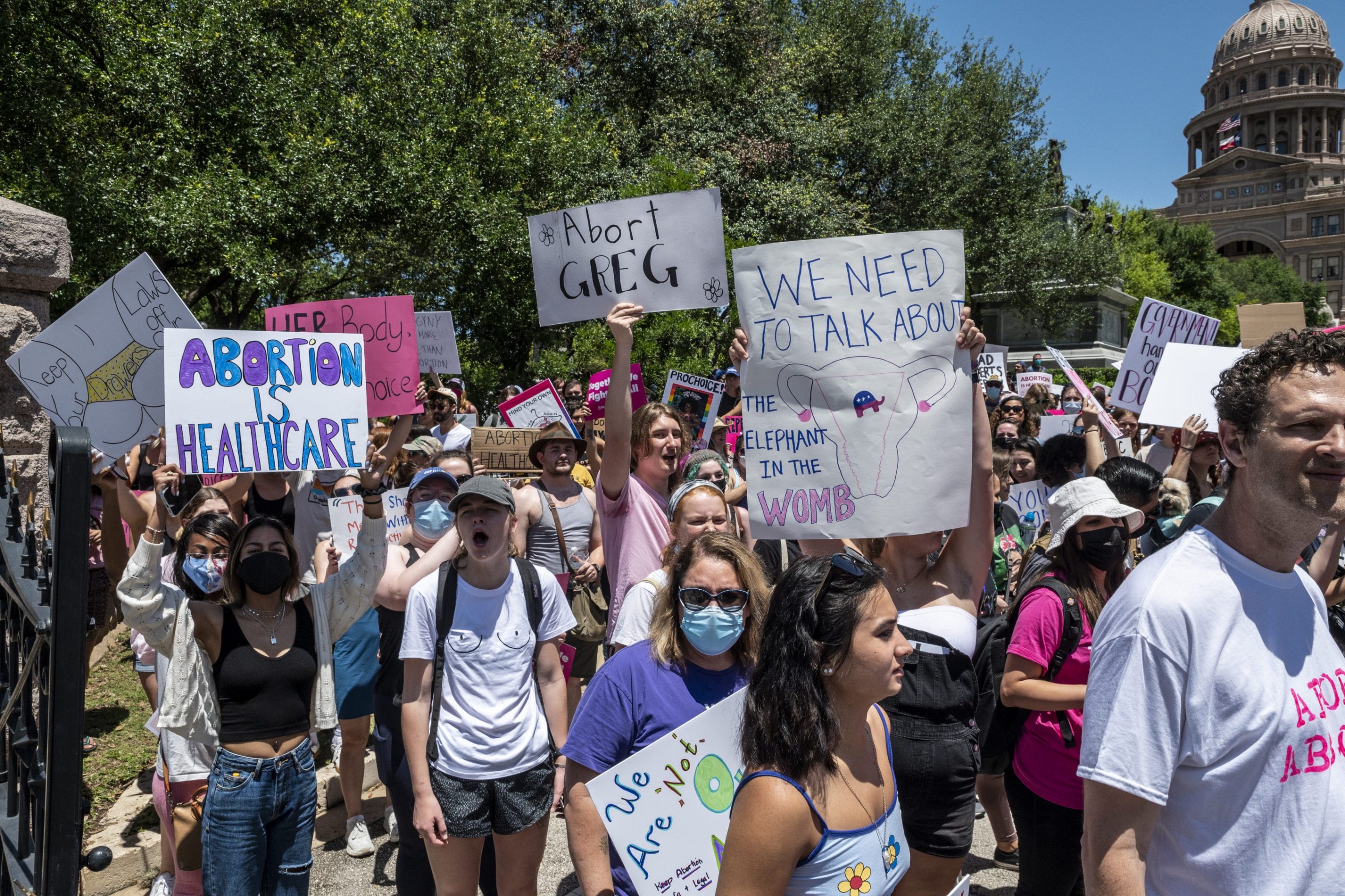 Protesters hold up signs as they march down Congress Ave at a protest outside the Texas state capitol on May 29, 2021 in Austin, Texas. Thousands of protesters came out in response to a new bill outlawing abortions after a fetal heartbeat is detected signed on Wednesday by Texas Governor Greg Abbot.