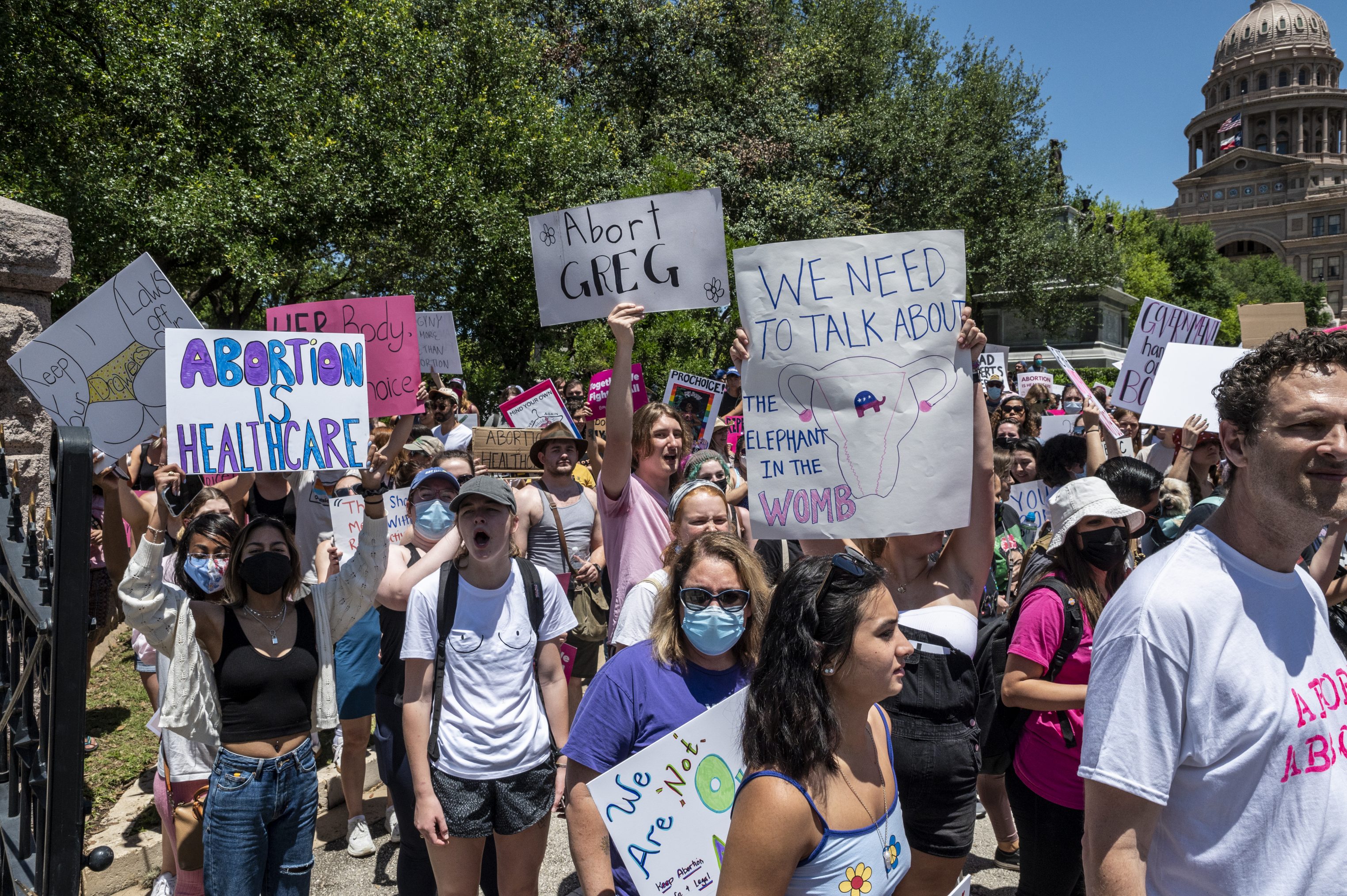 Protesters hold up signs as they march down Congress Ave at a protest outside the Texas state capitol on May 29, 2021 in Austin, Texas. Thousands of protesters came out in response to a new bill outlawing abortions after a fetal heartbeat is detected signed on Wednesday by Texas Governor Greg Abbot.