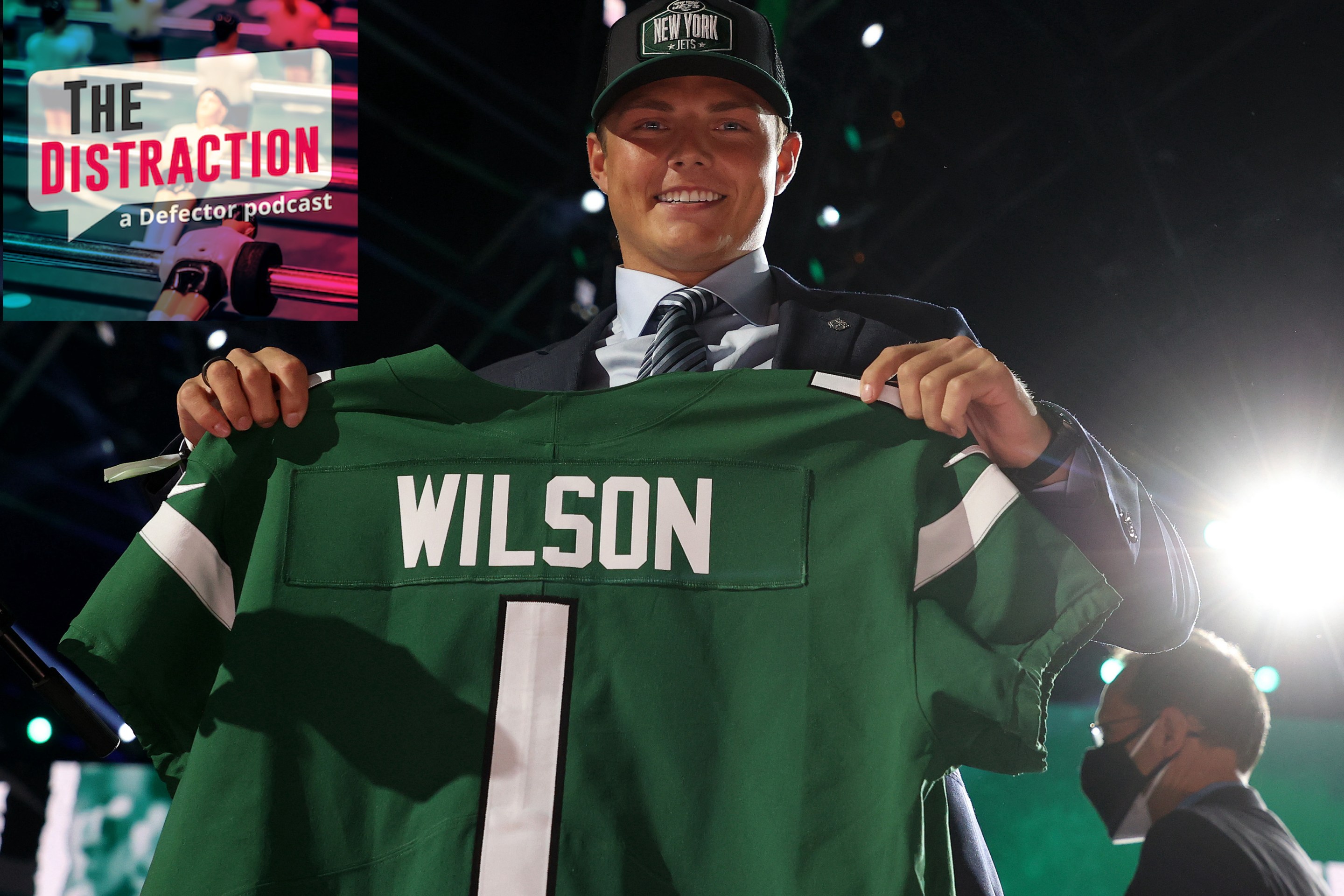 Jets quarterback Zach Wilson holding up his jersey on draft night, quite possibly the last time he will experience joy near such a jersey.