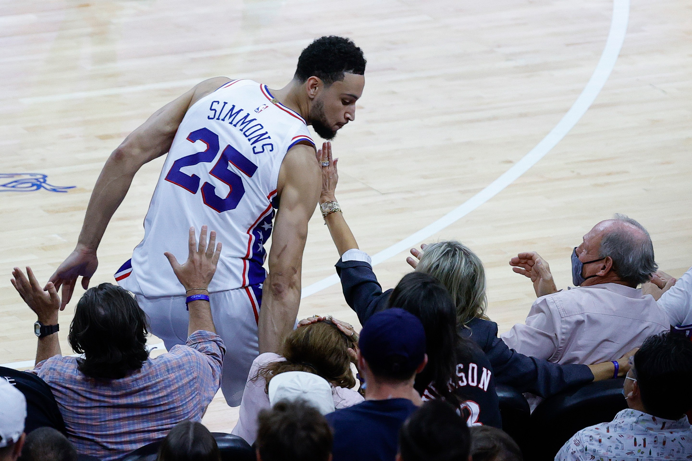 Ben Simmons falls into the court-side seats.