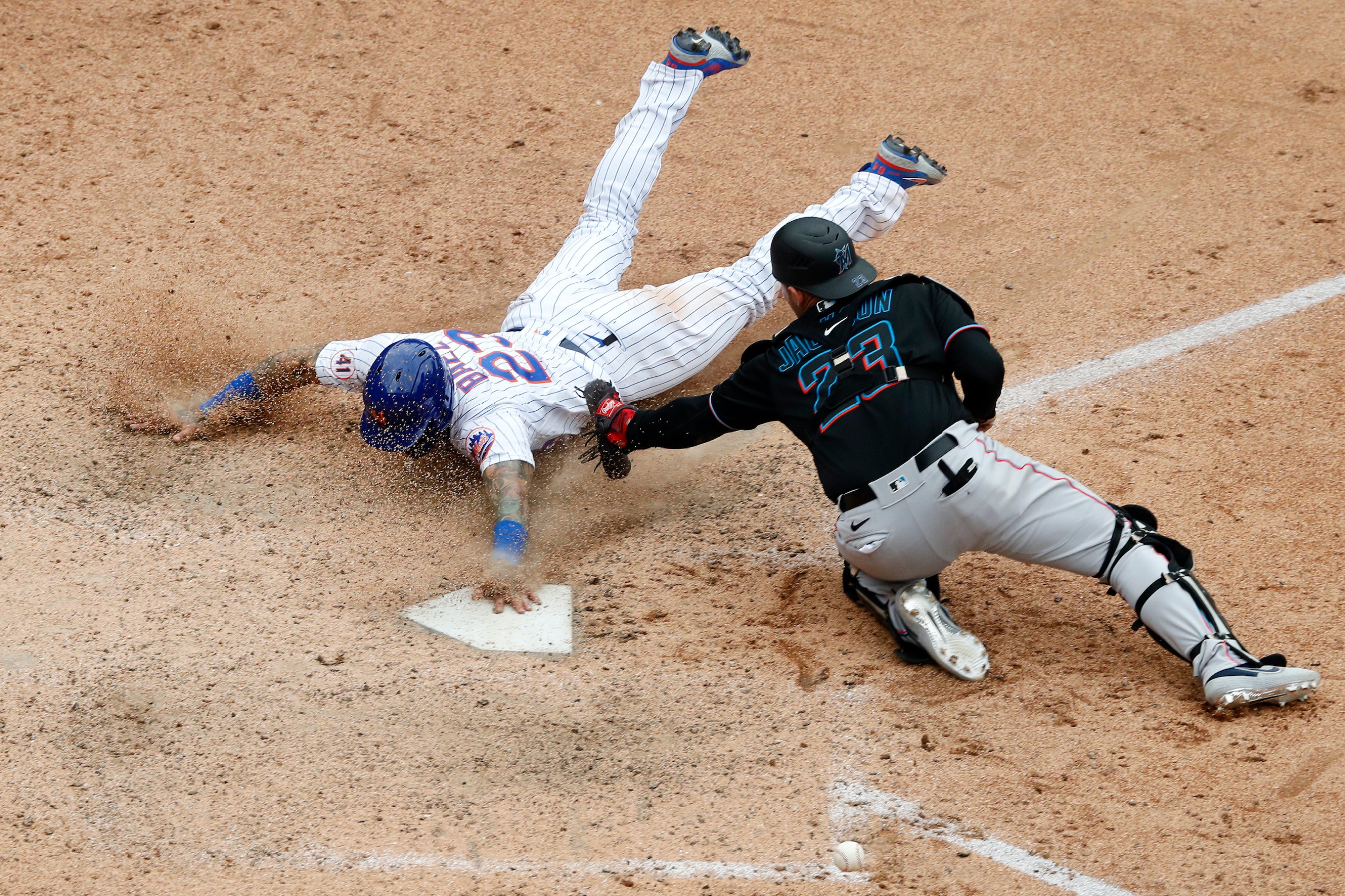 Javier Baez #23 of the New York Mets slides home with the game winning run in the ninth inning against Alex Jackson #23 of the Miami Marlins at Citi Field on August 31, 2021 in New York City.