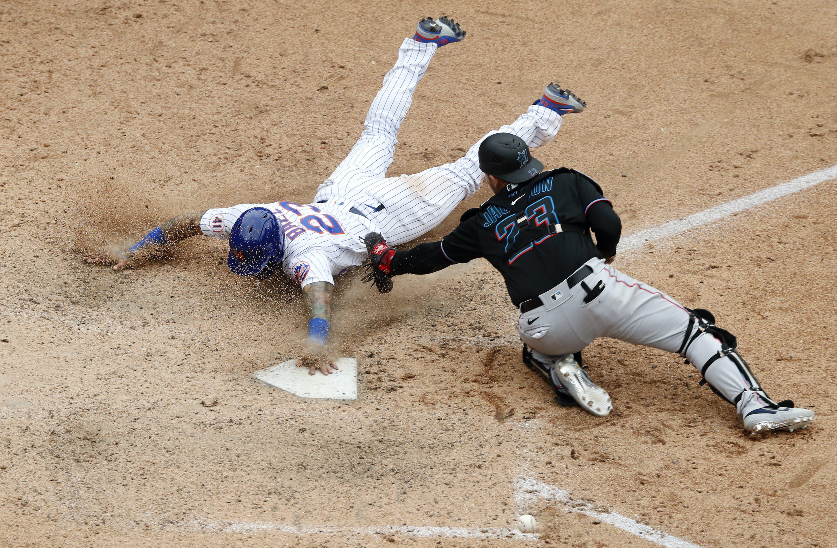 Javier Baez #23 of the New York Mets slides home with the game winning run in the ninth inning against Alex Jackson #23 of the Miami Marlins at Citi Field on August 31, 2021 in New York City.