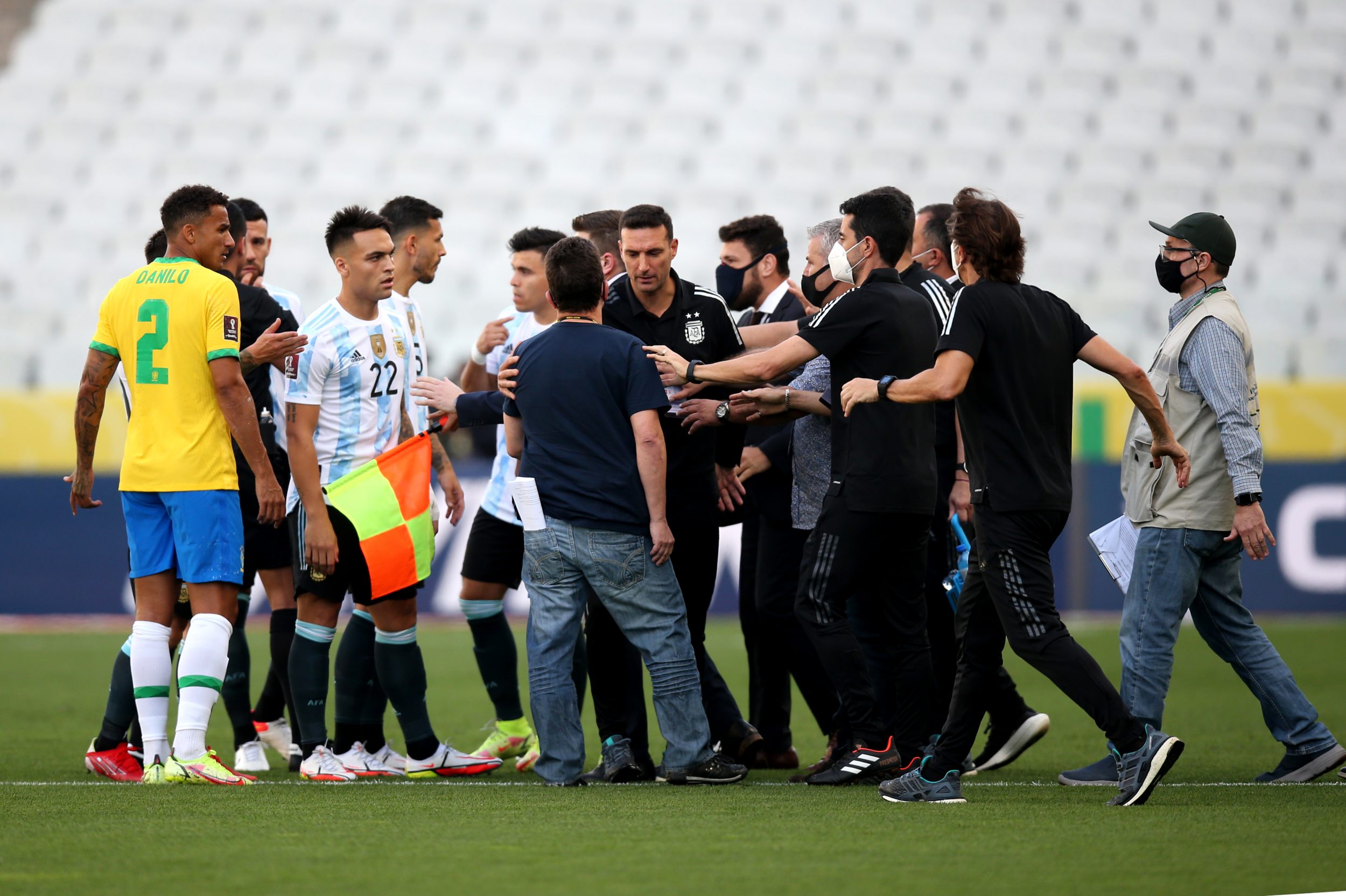 Health staff members argue with head coach of Argentina Lionel Scaloni and players of Brazil and Argentina during a match.