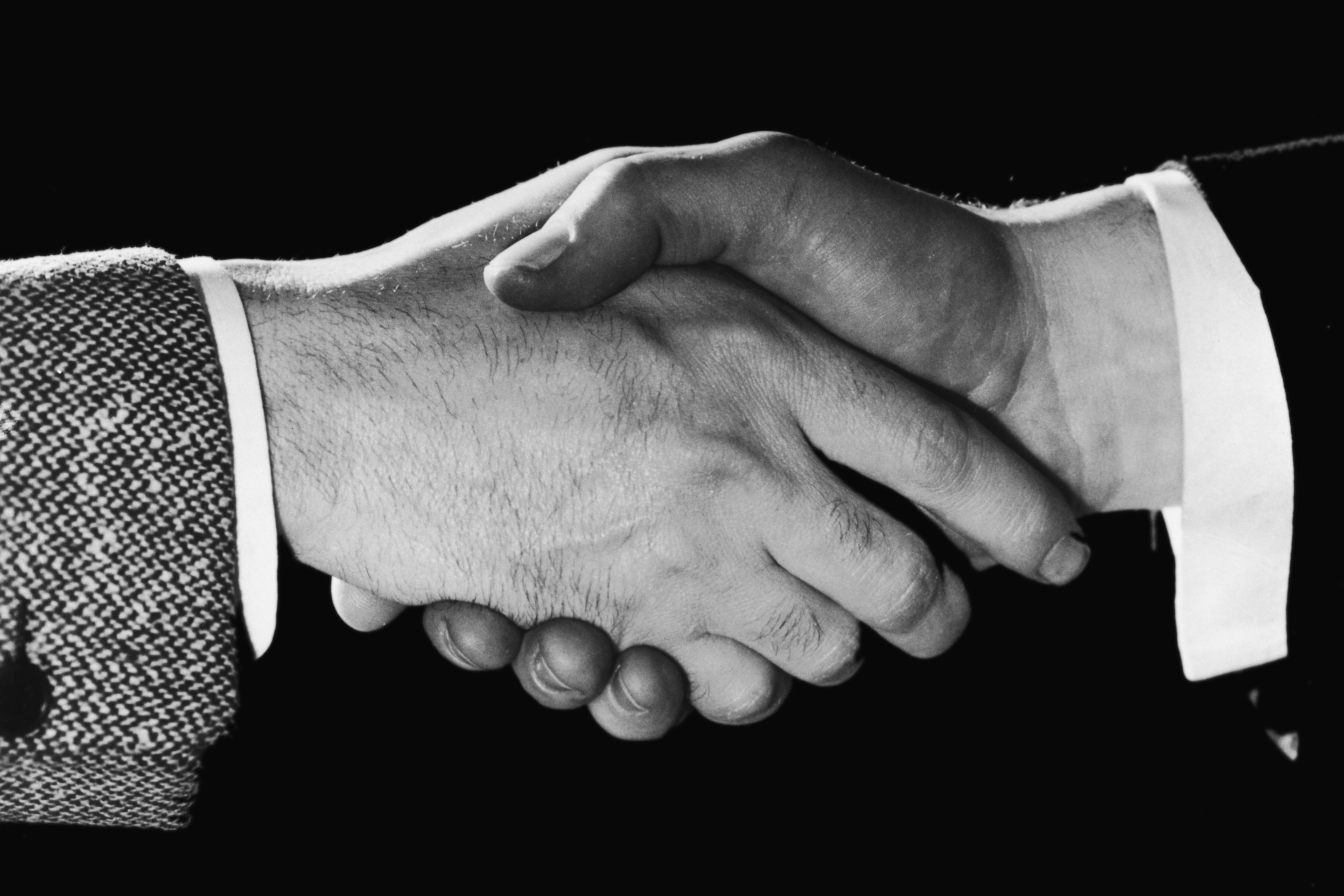A close-up of two men shaking hands, circa 1948.