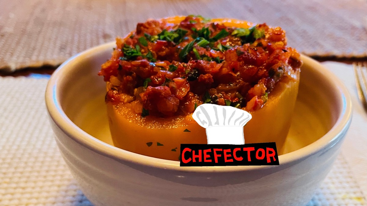 A stuffed orange pepper, looking very delicious in a bowl