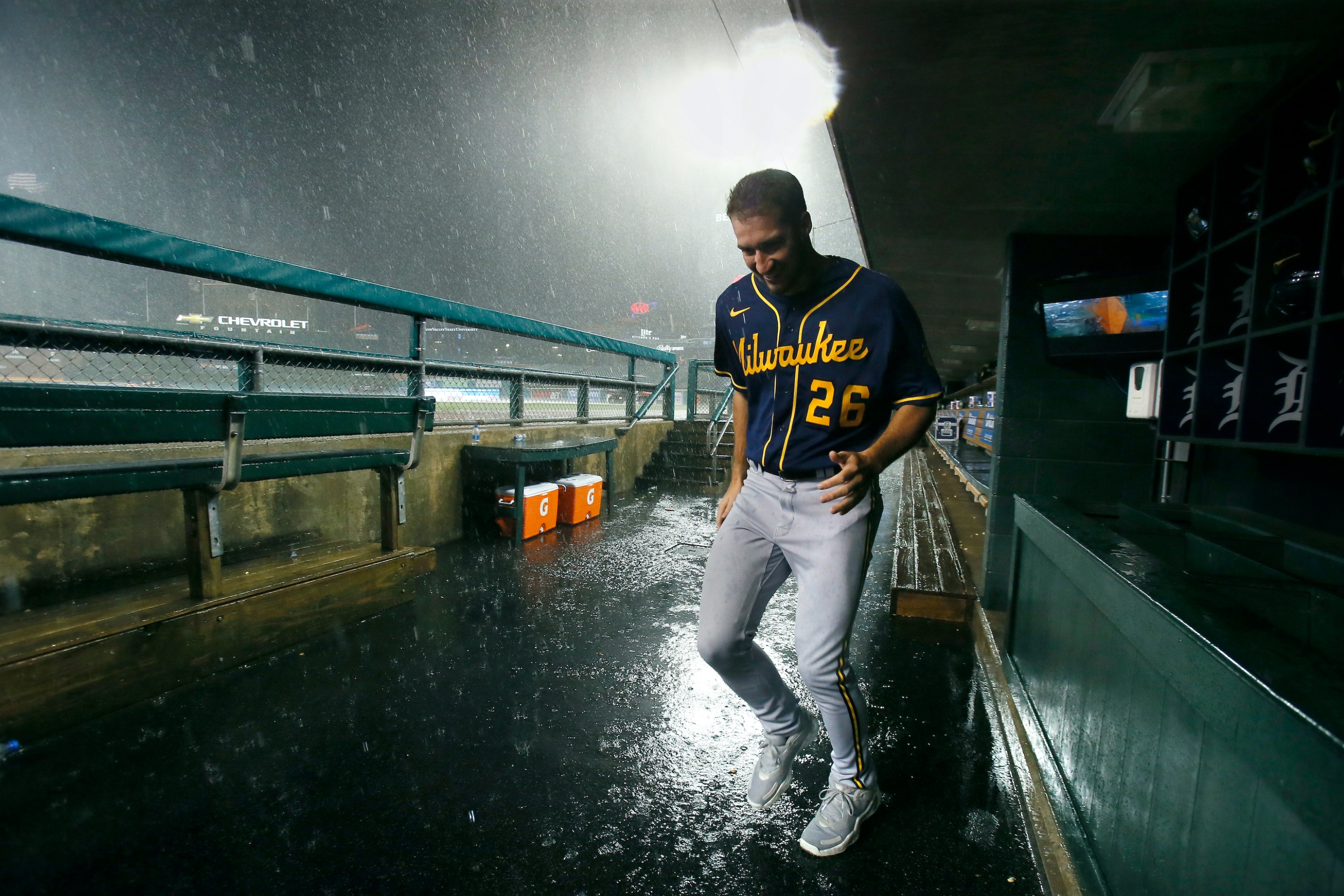 Pitcher Aaron Ashby #26 of the Milwaukee Brewers tries to stay dry as he leaves the dugout as a thunderstorm moves through the area following the sixth inning of a game against the Detroit Tigers at Comerica Park on September 14, 2021, in Detroit, Michigan.