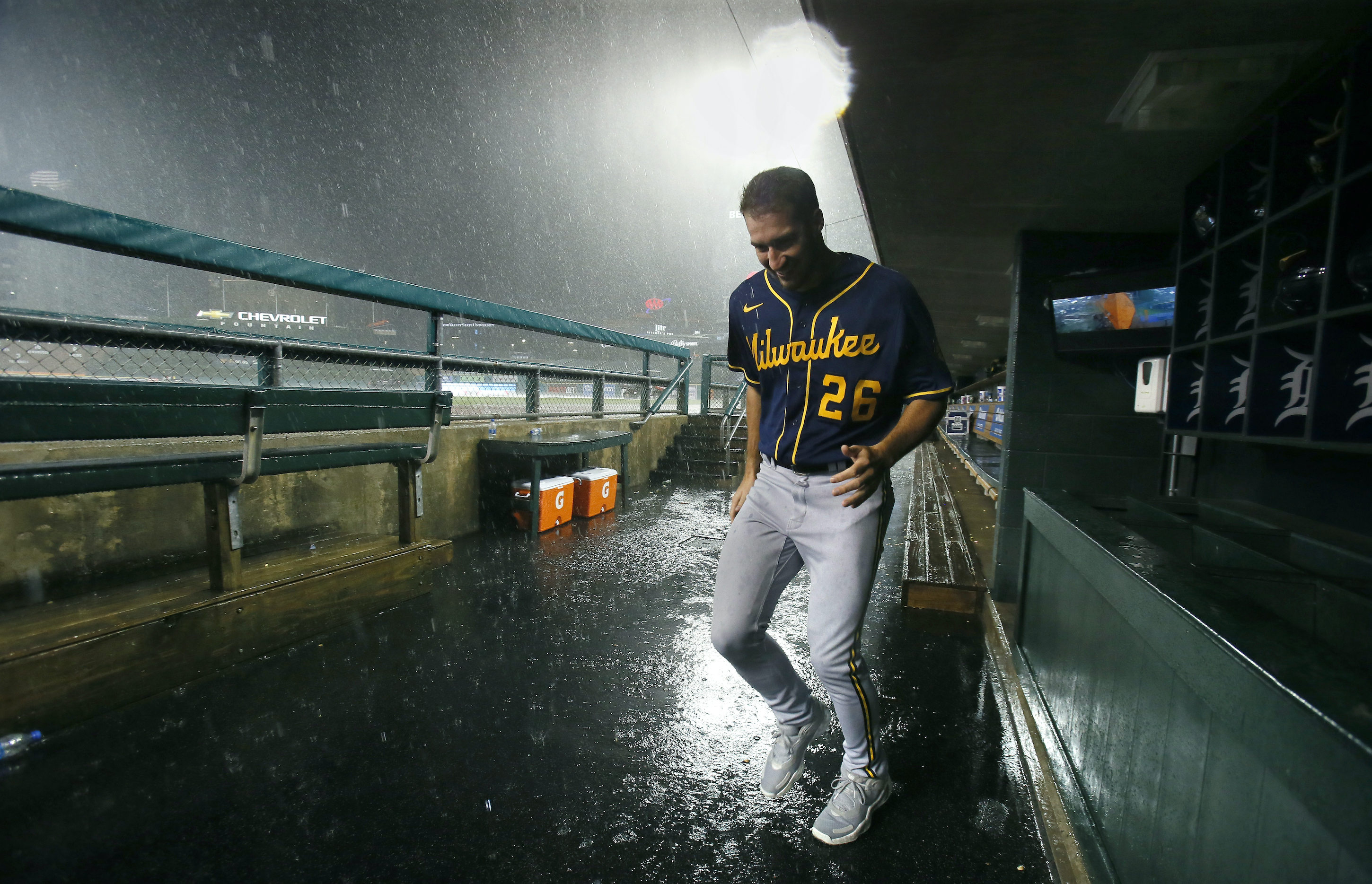 Pitcher Aaron Ashby #26 of the Milwaukee Brewers tries to stay dry as he leaves the dugout as a thunderstorm moves through the area following the sixth inning of a game against the Detroit Tigers at Comerica Park on September 14, 2021, in Detroit, Michigan.