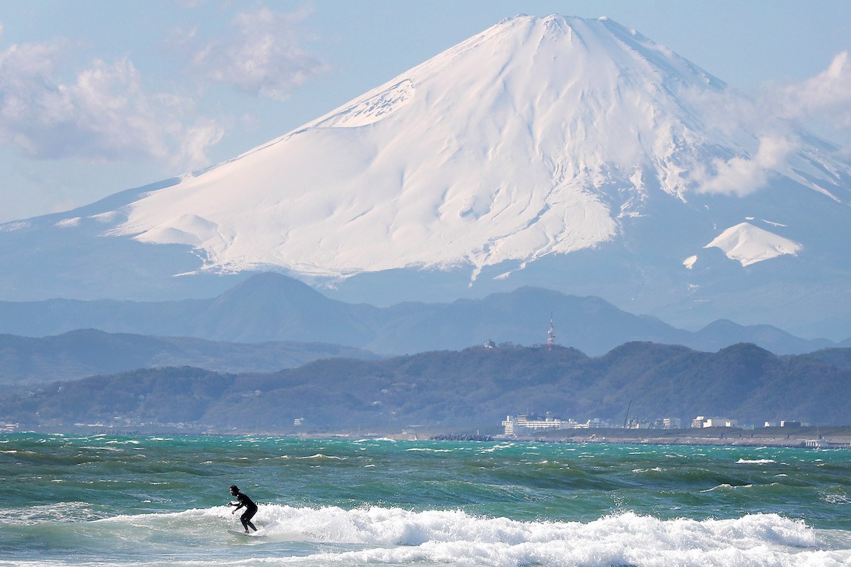 TOKYO, JAPAN - JANUARY 30: A local surfer is seen in action with Mount Fuji in the background from the beach of Enoshima during the build up to the Tokyo 2020 Olympic Games on January 30, 2020 in Fujisawa, Kanagawa Prefecture, Japan. The venue will hold the sailing events. (Photo by Clive Rose/Getty Images)