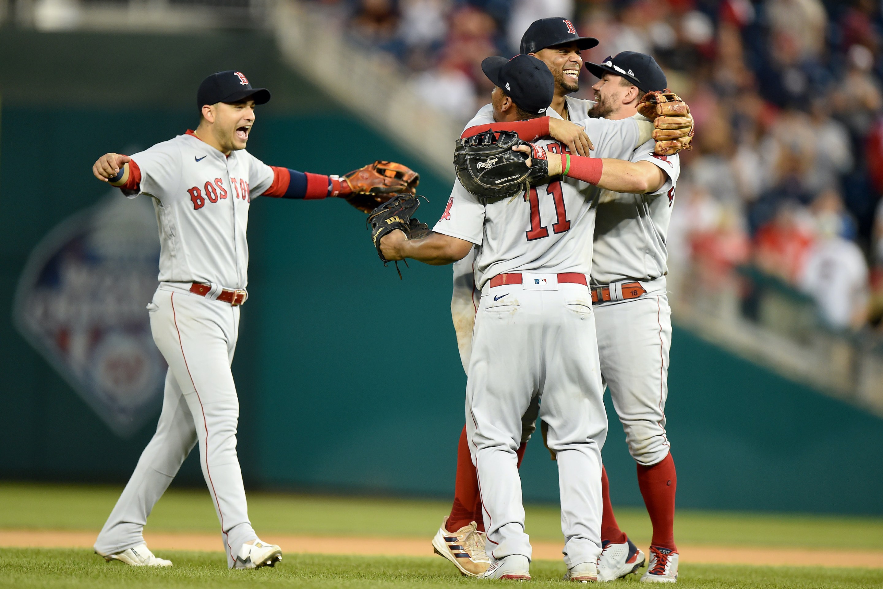Jose Iglesias #12, Xander Bogaerts #2, Rafael Devers #11 and Kyle Schwarber #18 of the Boston Red Sox celebrate after a 7-5 victory against the Washington Nationals at Nationals Park on October 03, 2021 in Washington, DC.