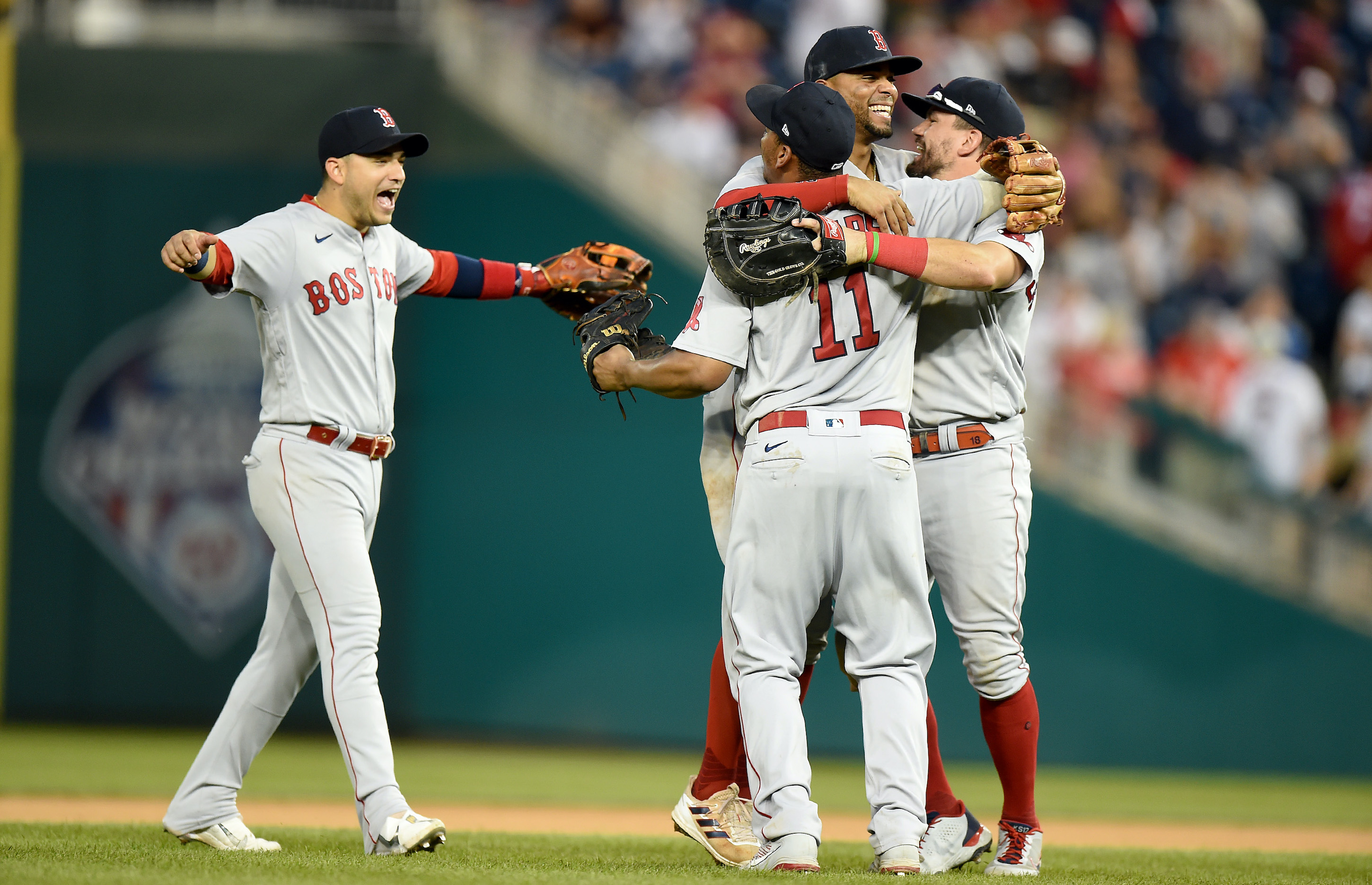 Jose Iglesias #12, Xander Bogaerts #2, Rafael Devers #11 and Kyle Schwarber #18 of the Boston Red Sox celebrate after a 7-5 victory against the Washington Nationals at Nationals Park on October 03, 2021 in Washington, DC.