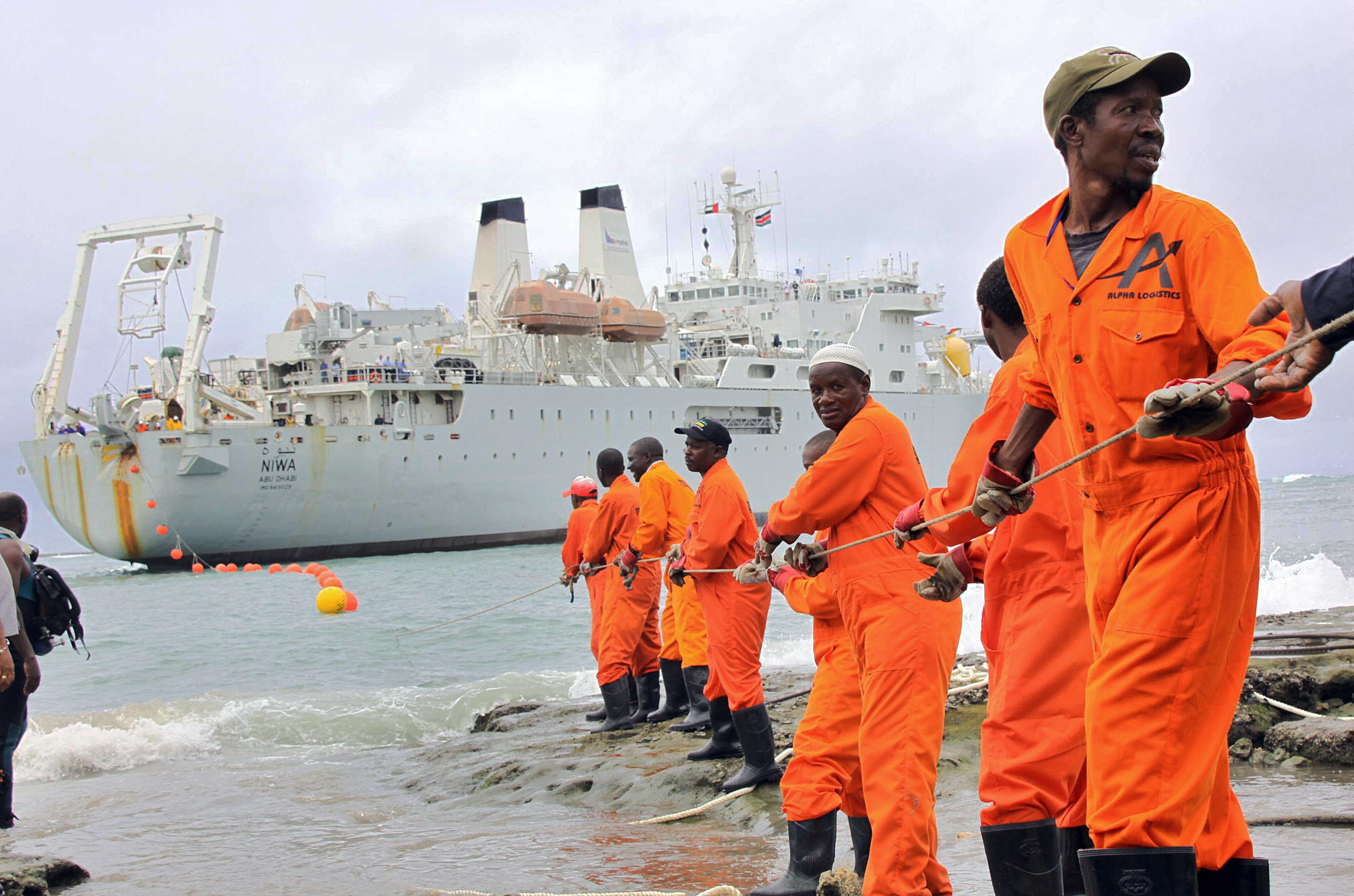 Workers haul part of a fibre optic cable onto the shore at the Kenyan port town of Mombasa on June 12, 2009. An undersea fibre optic cable bringing broadband Internet connectivity to east Africa, reached the Kenyan coast from the United Arab Emirates on Friday, the president said. The East Africa Marine Systems (TEAMS) fibre optic submarine cable project is a joint venture of the Kenyan government and Emirates Telecommunication Technology (Etisalat) and a consortium of local investors. AFP PHOTO (Photo credit should read STRINGER/AFP via Getty Images)