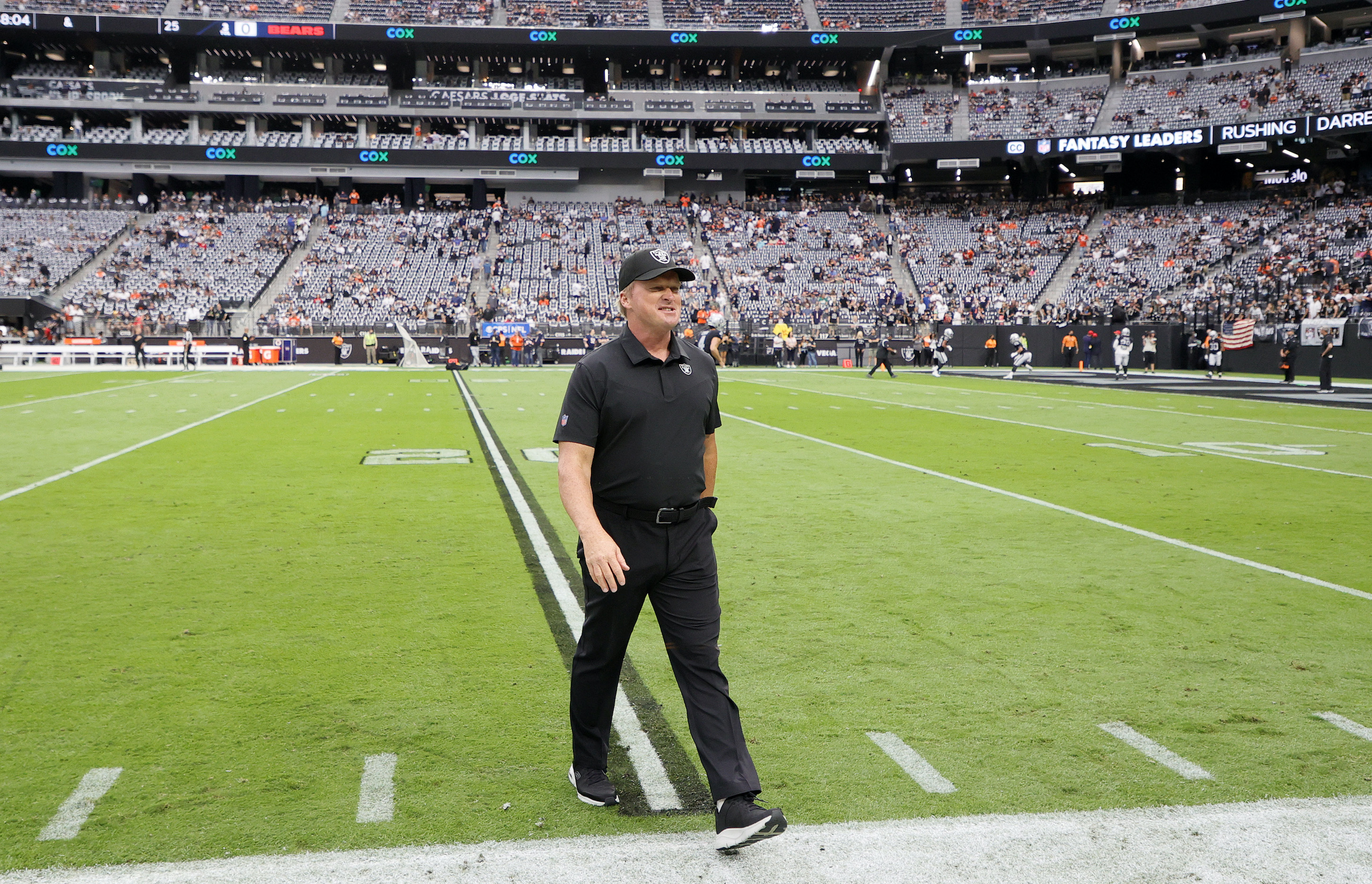 Head coach John Gruden of the Las Vegas Raiders walks on the field before a game against the Chicago Bears at Allegiant Stadium.
