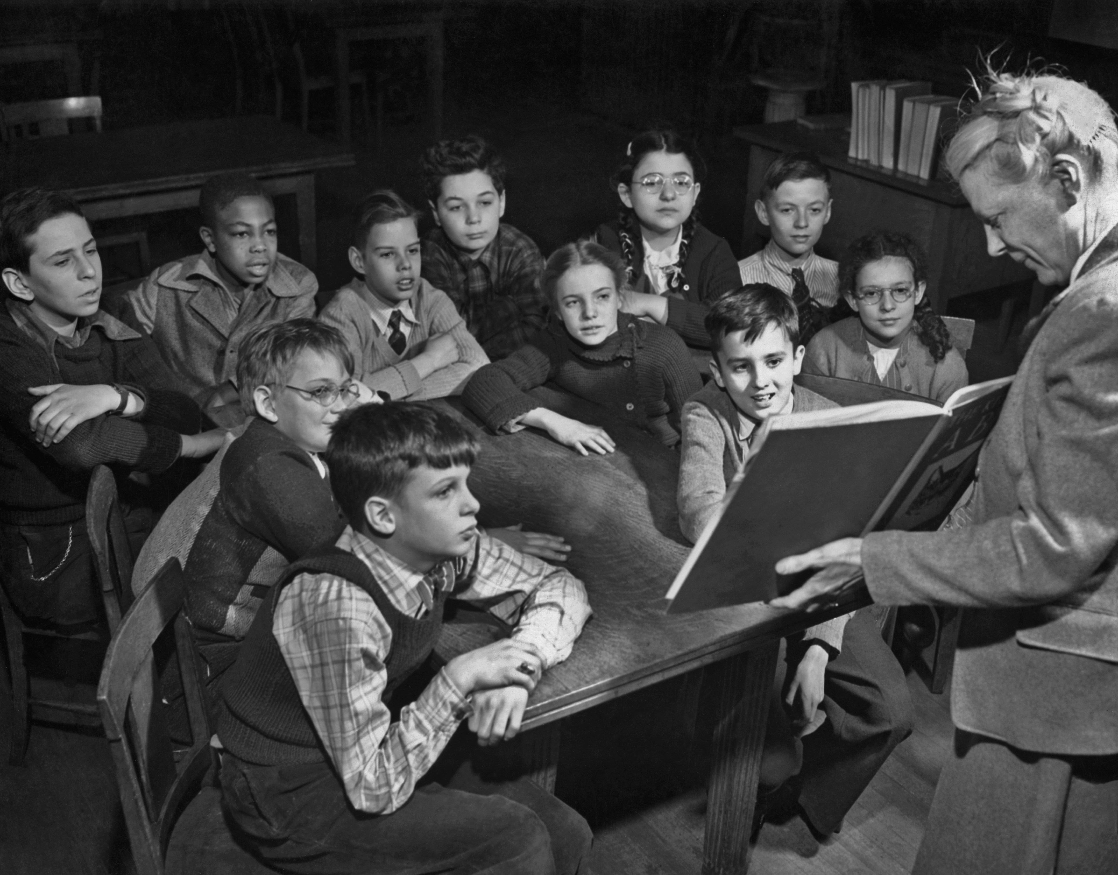A library teacher giving a class to a group of boys and girls at a New York City public school, circa 1950.