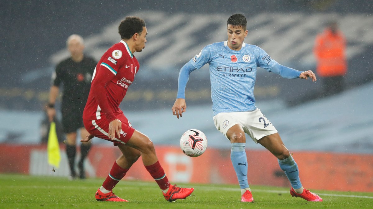 Joao Cancelo of Manchester City is challenged by Trent Alexander-Arnold of Liverpool during the Premier League match between Manchester City and Liverpool at Etihad Stadium on November 08, 2020 in Manchester, England.