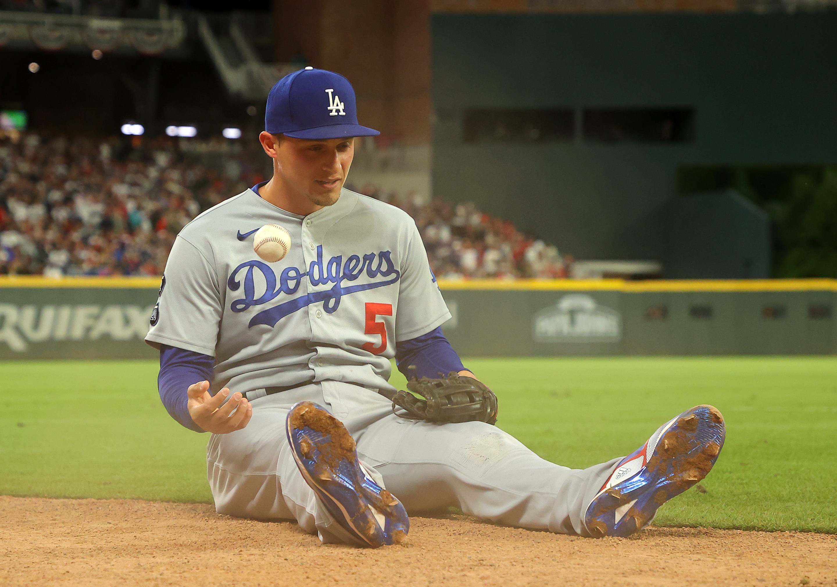 Corey Seager, seen here sitting on his butt tossing a baseball up in the air back when he was with the Dodgers, and before he joined the Rangers.