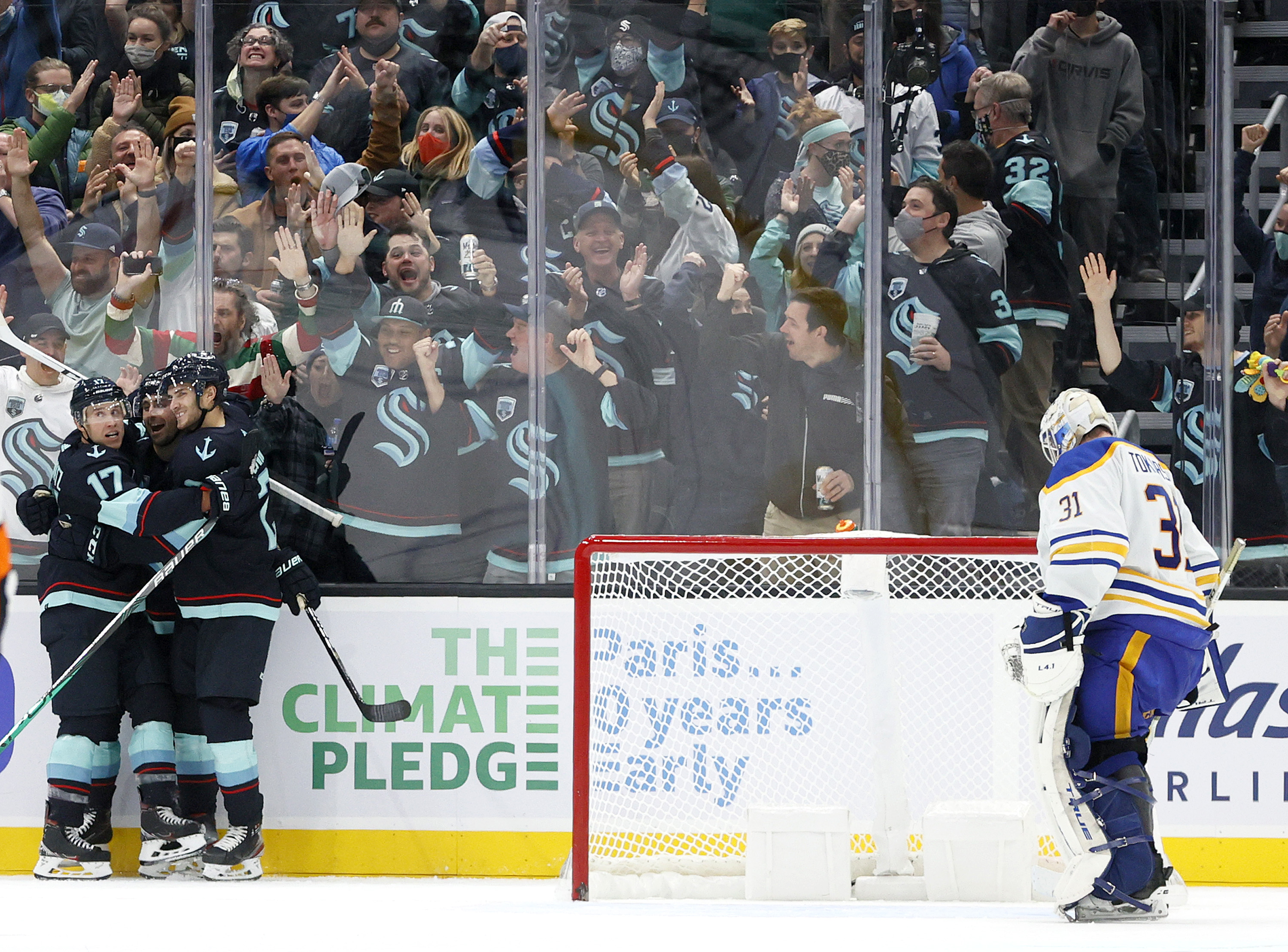 Jordan Eberle #7 of the Seattle Kraken celebrates his hat trick with Jaden Schwartz #17 and Alex Wennberg #21 against Dustin Tokarski #31 of the Buffalo Sabres during the third period at Climate Pledge Arena on November 04, 2021 in Seattle, Washington.
