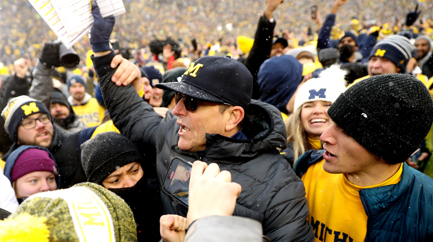 ANN ARBOR, MICHIGAN - NOVEMBER 27: Head Coach Jim Harbaugh of the Michigan Wolverines celebrates with fans after defeating the Ohio State Buckeyes at Michigan Stadium on November 27, 2021 in Ann Arbor, Michigan. (Photo by Mike Mulholland/Getty Images)